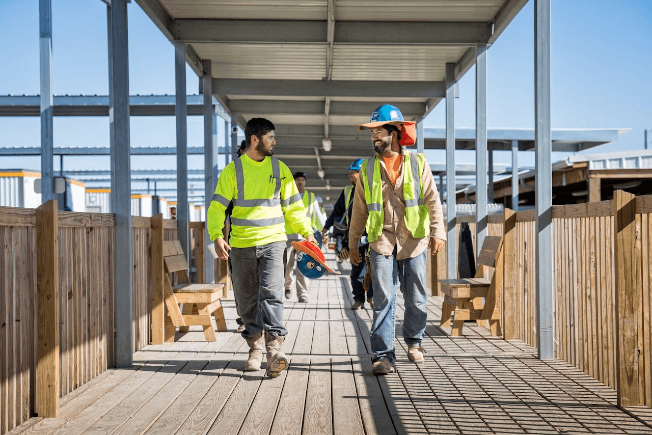 Workers walking through a covered boardwalk at Moss Lake Village.