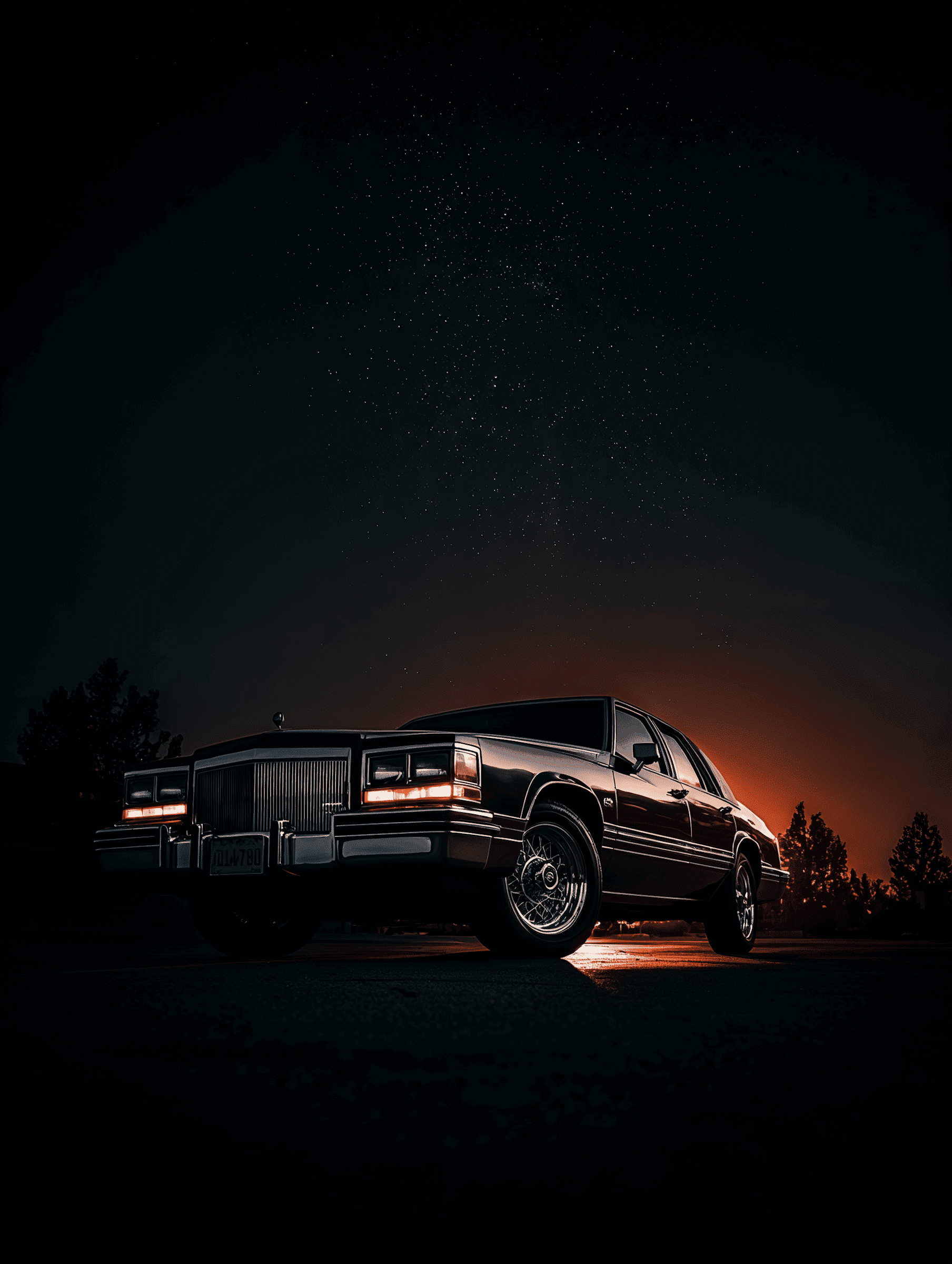Black sports car parked under a starry night sky with mountains in the background