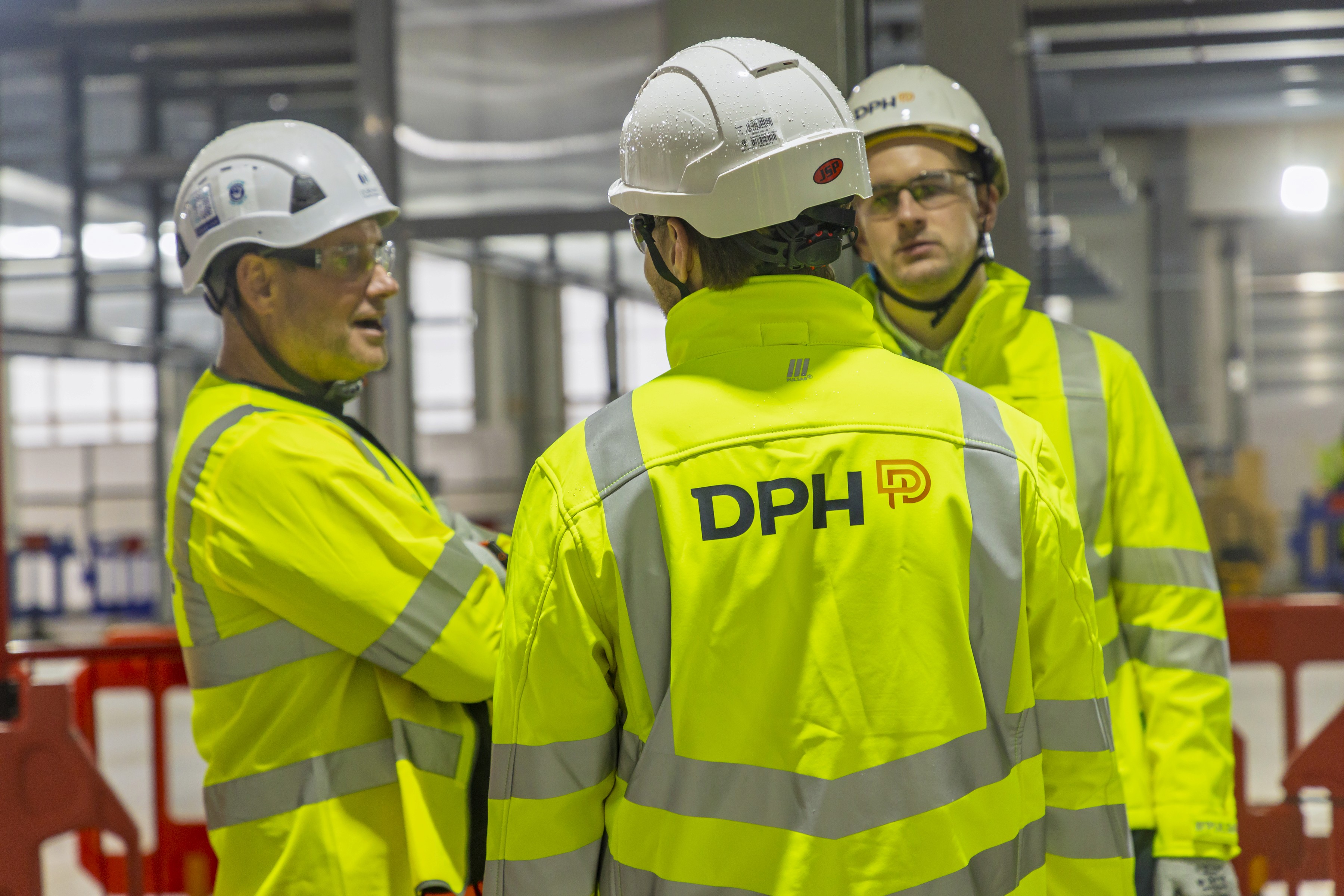 Modern glass buildings with illuminated facades and trees on a rainy day
