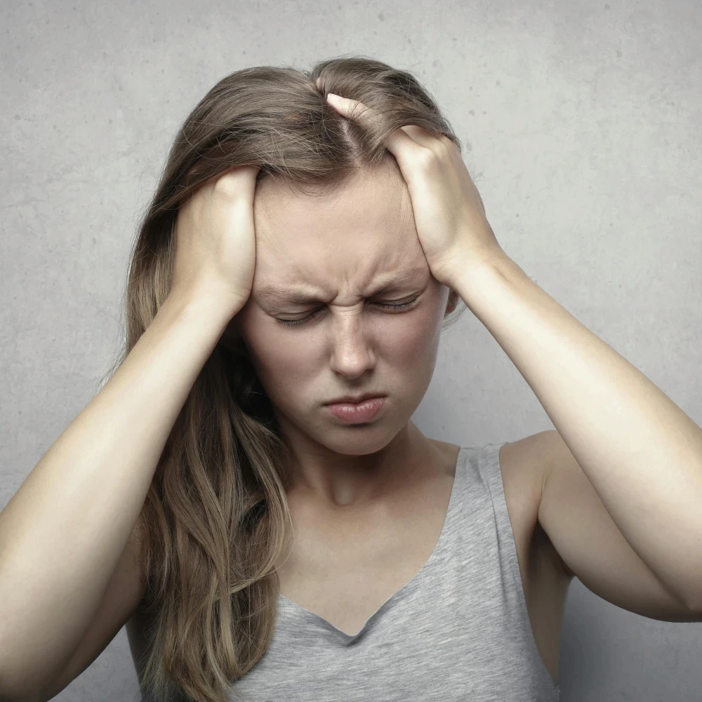 A woman holding her head in pain