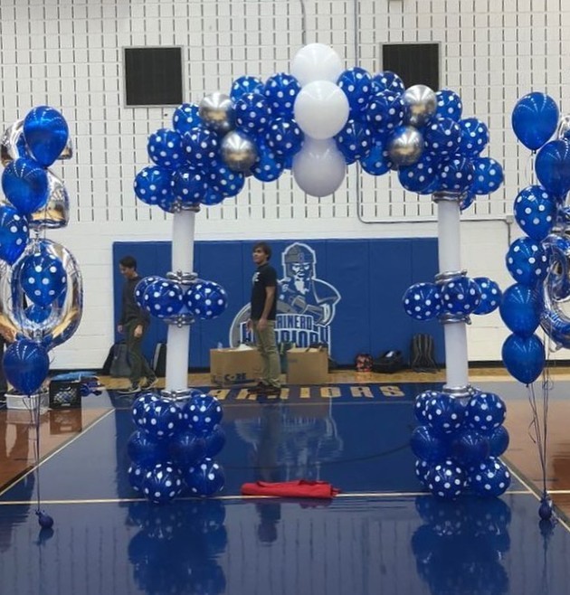 Blue and white balloon arch and column arrangement framing a nautical-themed display by Be Bold Balloons