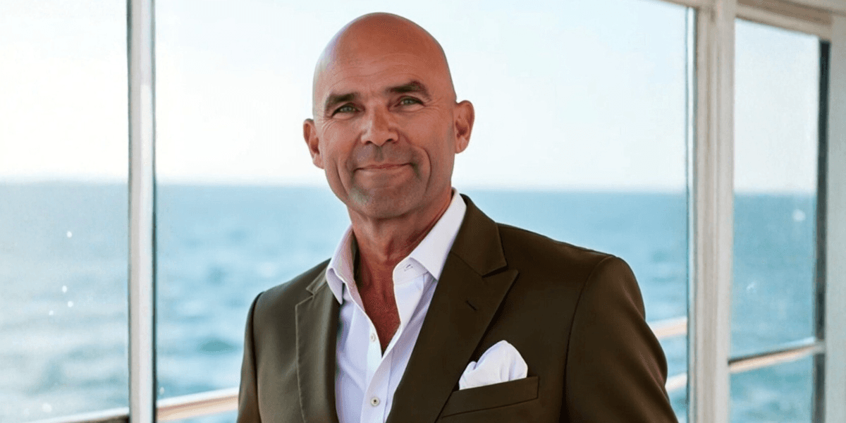 Brady Schmidt, CEO of Harvest Income Solutions, smiling in front of the ocean, embodying calm and secure retirement planning.