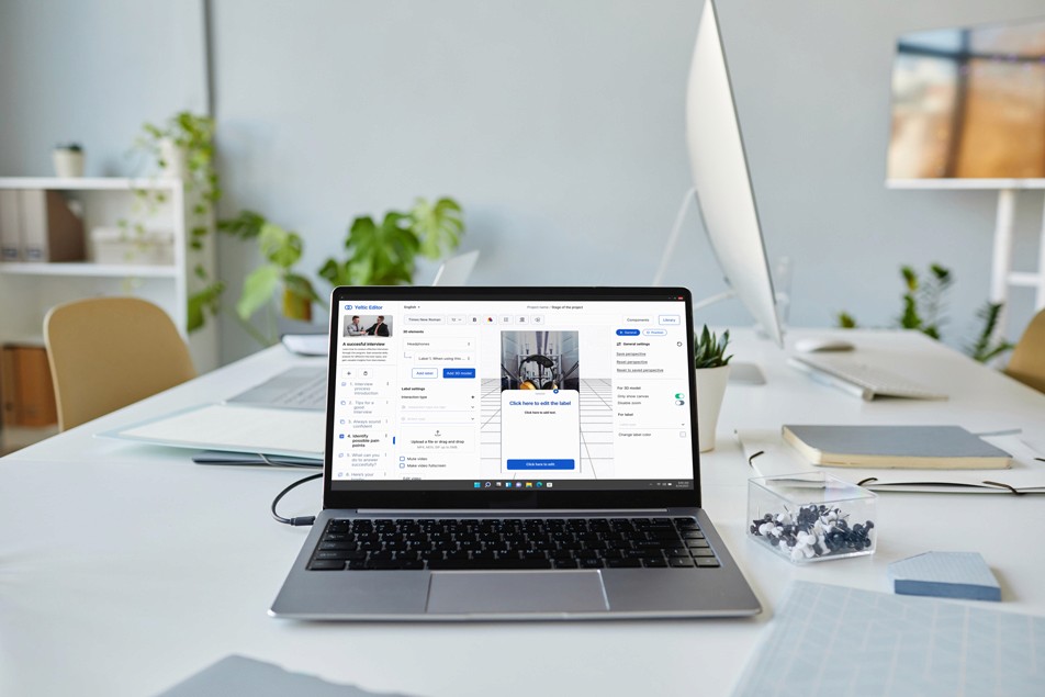 A MacBook with lines of code on its screen on a busy desk