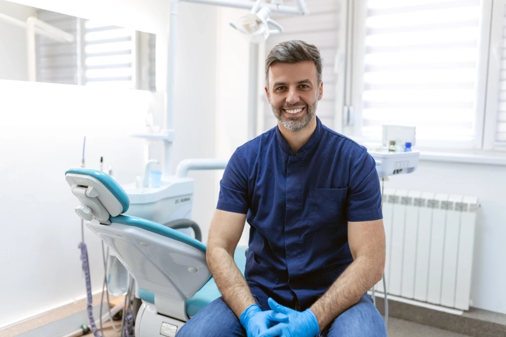 Dentist facing the camera and smiling