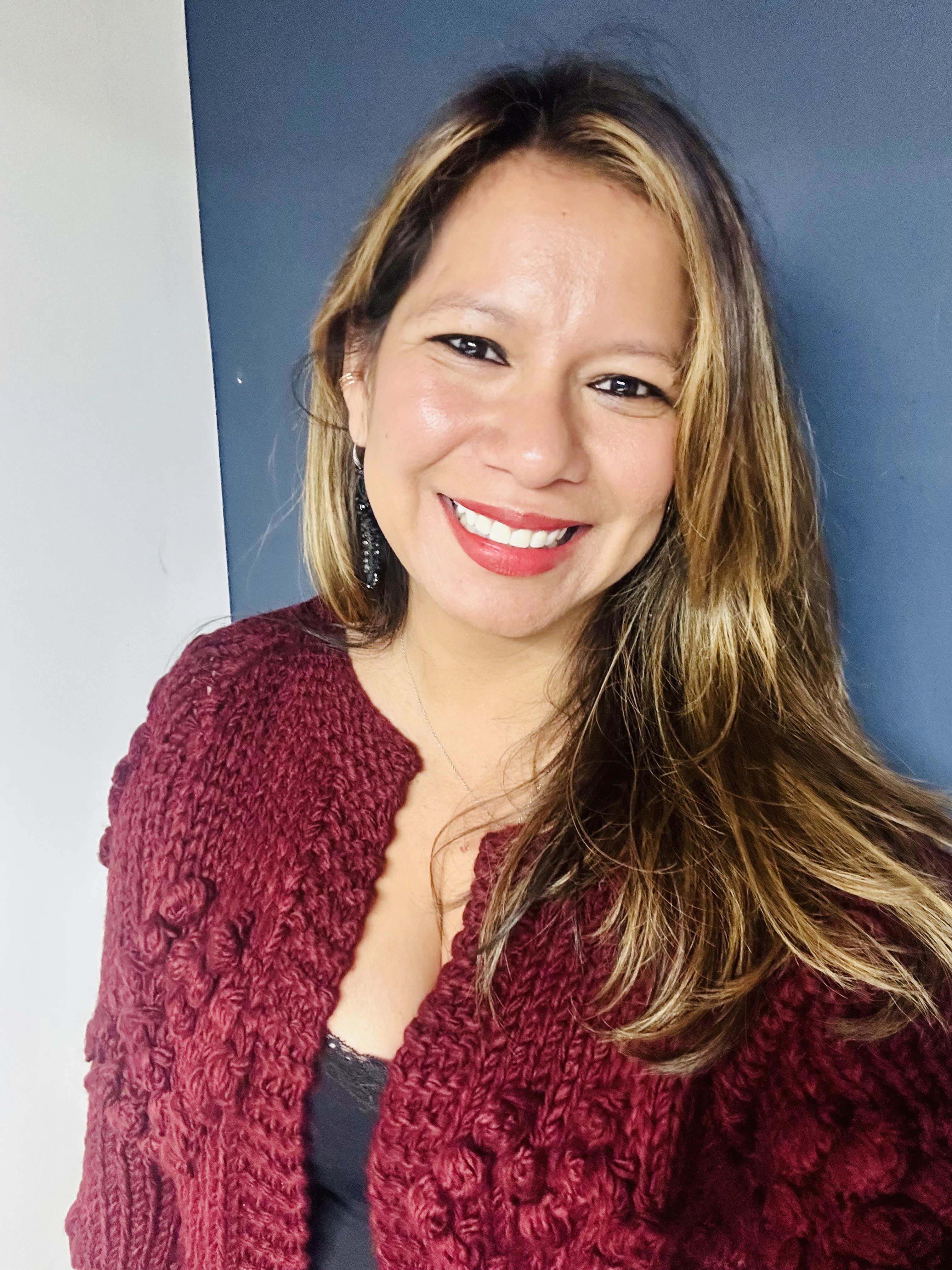 Portrait of Denix Alemendares, a Canadian immigrant and accountant with a warm smile. Denix is a mother and wife with roots in Honduras, where she grew up in challenging conditions that taught her resilience and bravery. At sixteen, she moved away from her village, attending night school while working during the day, determined to build a life of stability and kindness. Guided by what she calls her 'earth angels' and her 'secret heart,' Denix has created a life focused on perseverance and heartfelt dedication.