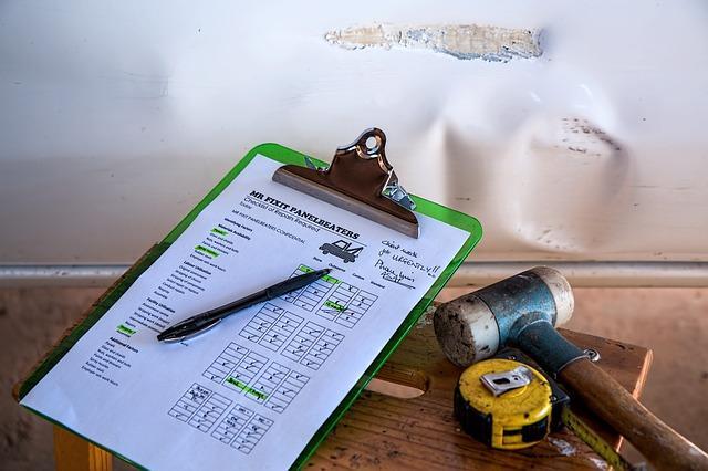 Checklist and tools next to damaged wall