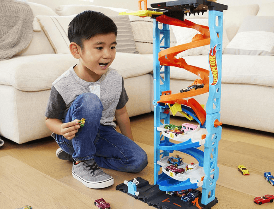 A boy playing with a car track toy