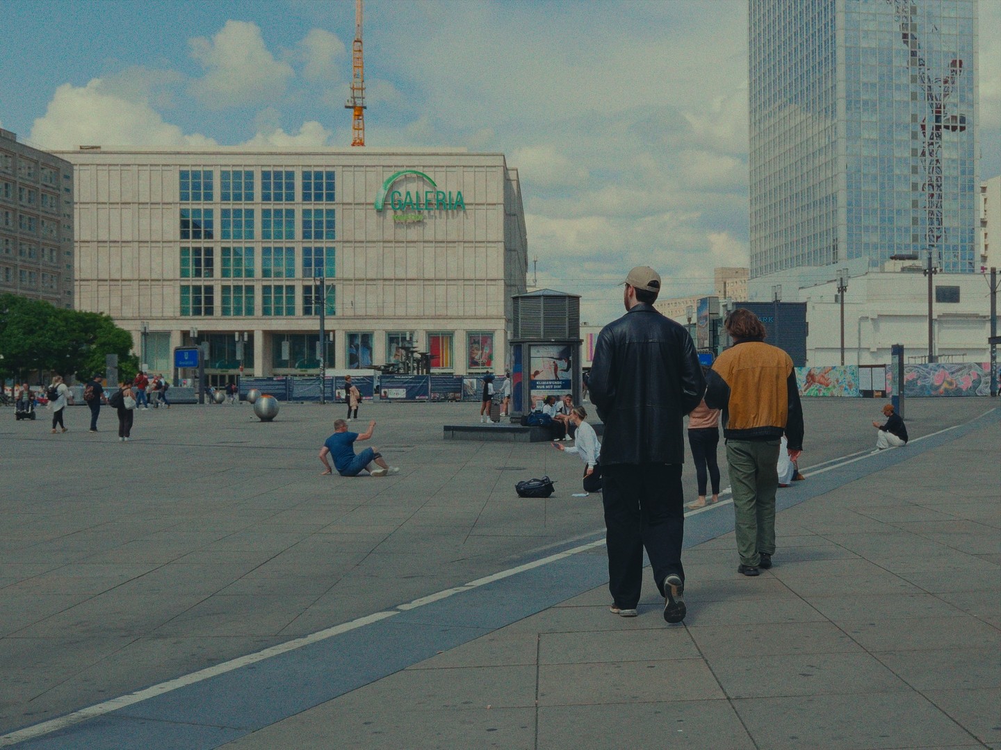 Promeneurs sur la place animée d'Alexanderplatz à Berlin, avec le magasin Galeria en arrière-plan.