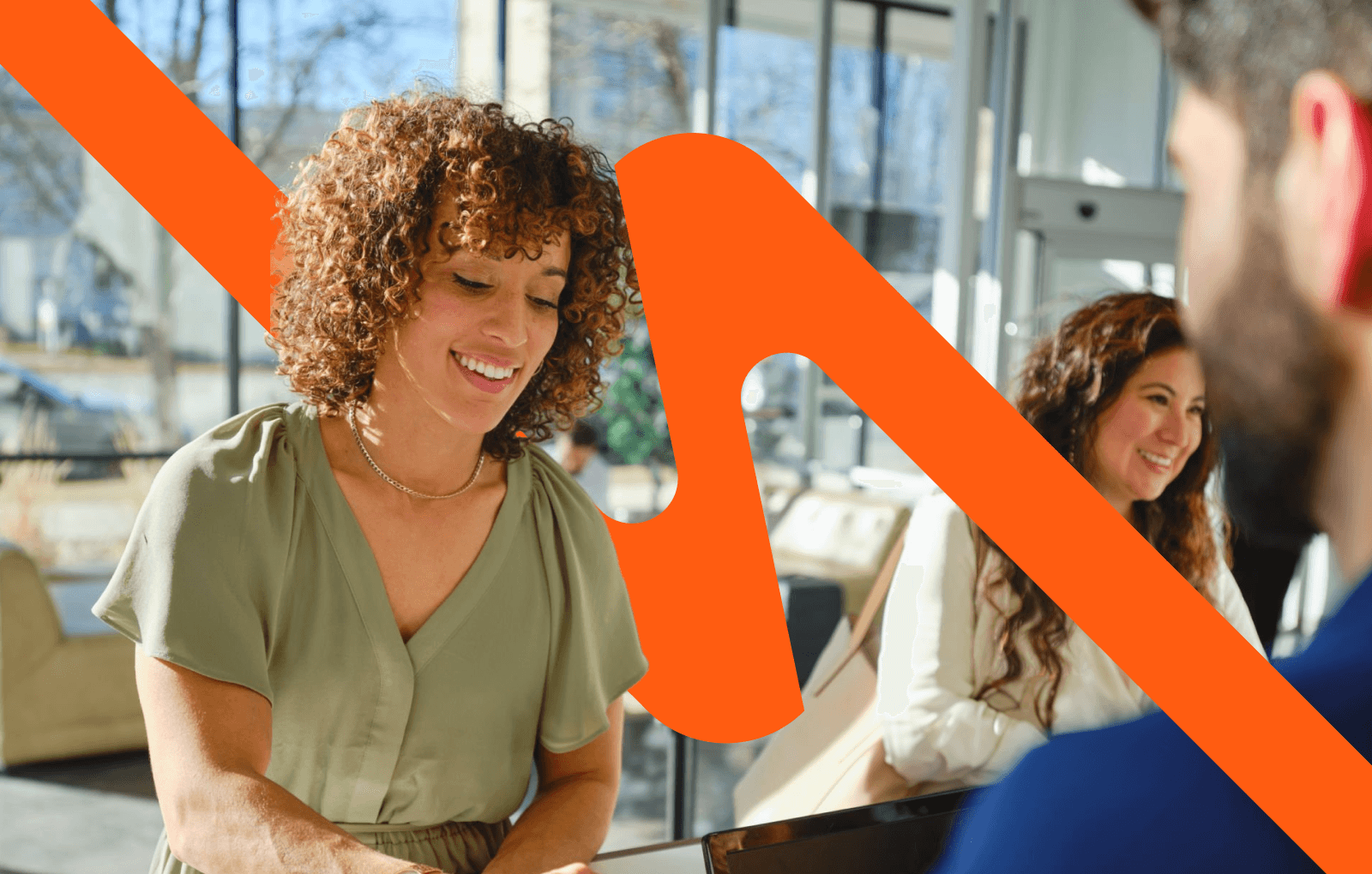 Vrouw in gesprek in een kantooromgeving met opvallende oranje grafische overlay.