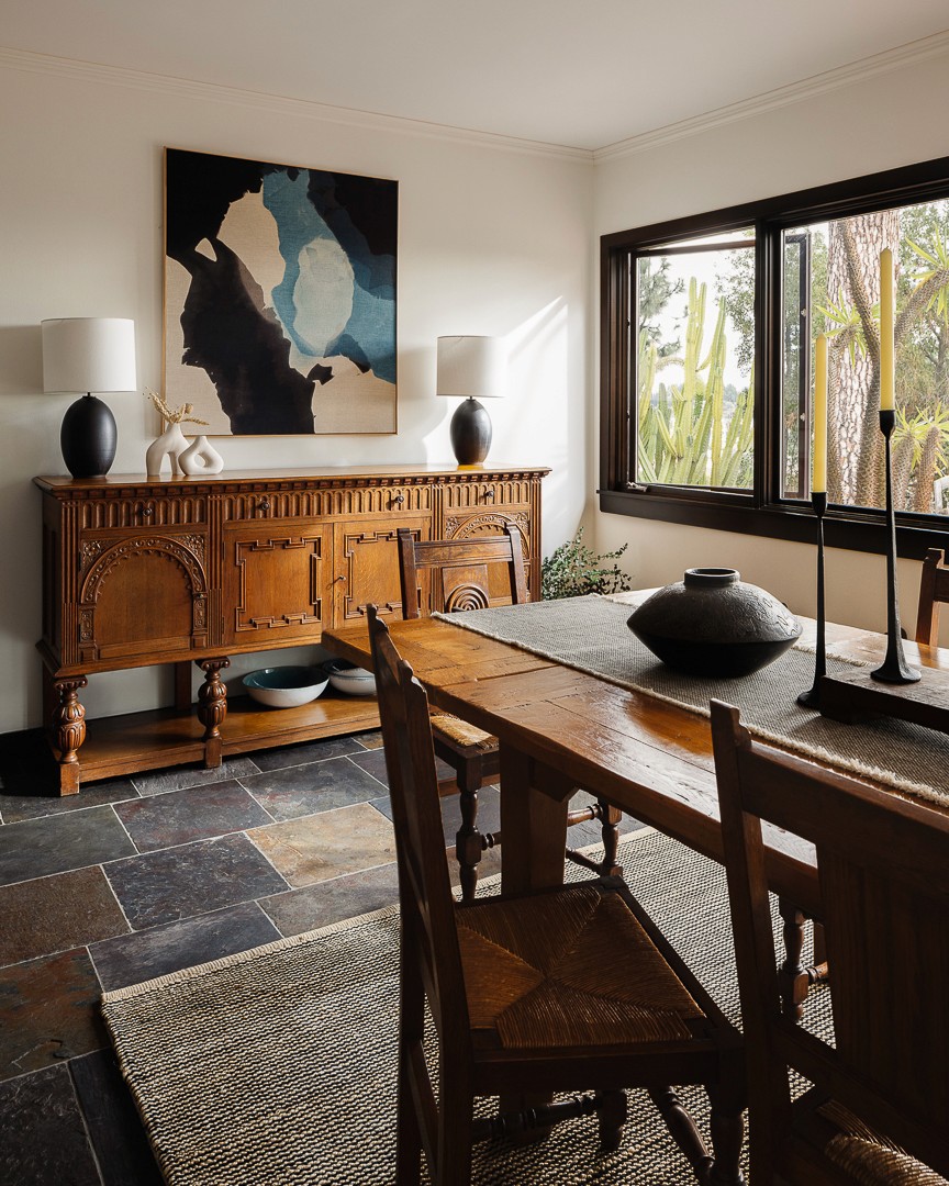 Sun beds with linen upholstery and accent pillows, complemented by stone, wood, and metal accents, create an elegant seating arrangement