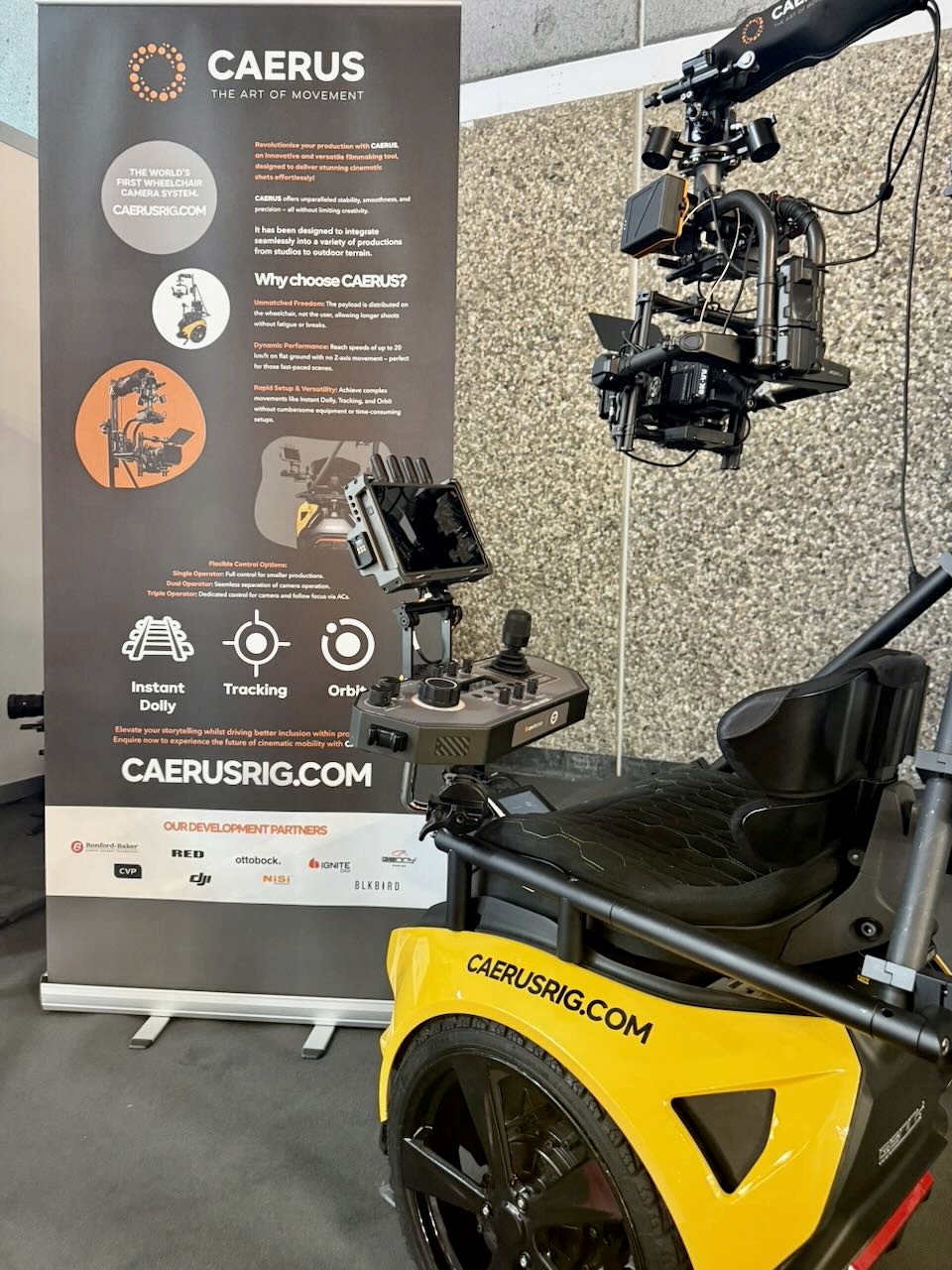 Shot of our display stand at IBC with an over the should style shot of the left rear side of CAERUS with one of our popup banners in the background