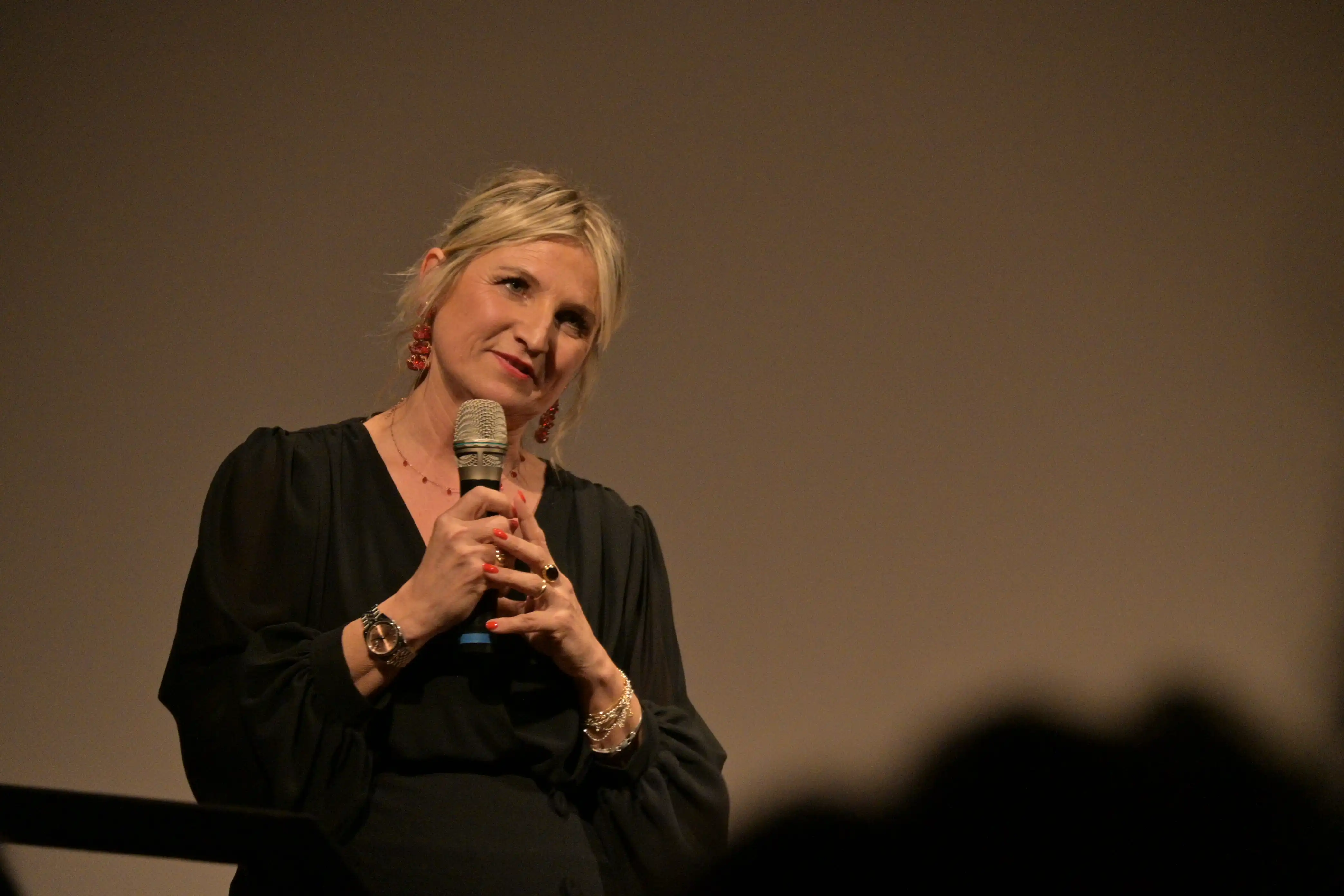 Dottoressa Silvia Donati con microfono presenta la serata Donne in Bilico sul palco del teatro Verdi di Forlimpopoli