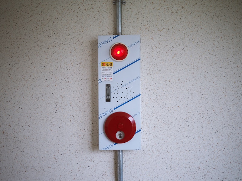 White alarm panel with a warning light and bell mounted on a wall