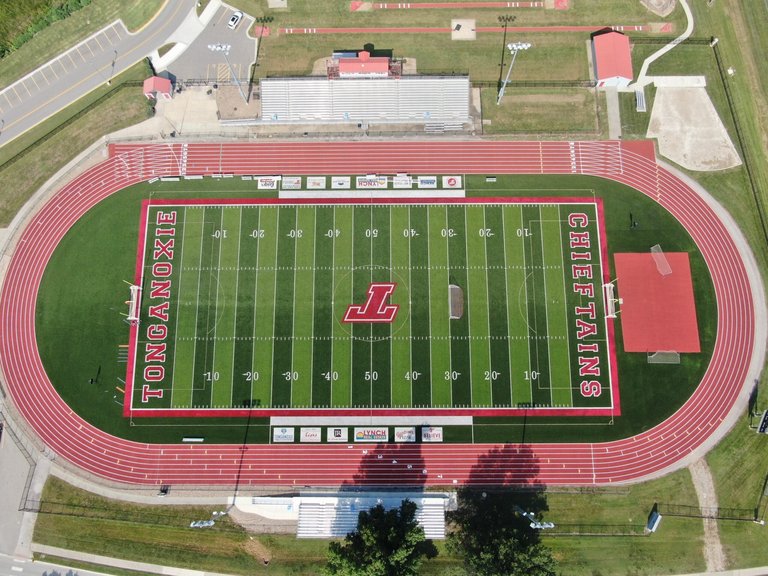 Aerial view of a standard high school running track surrounding a football field, showing the typical 400-meter oval layout.