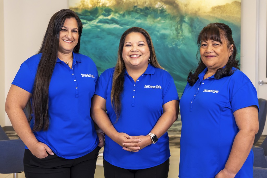 Three HMSA staff workers smile for a picture together