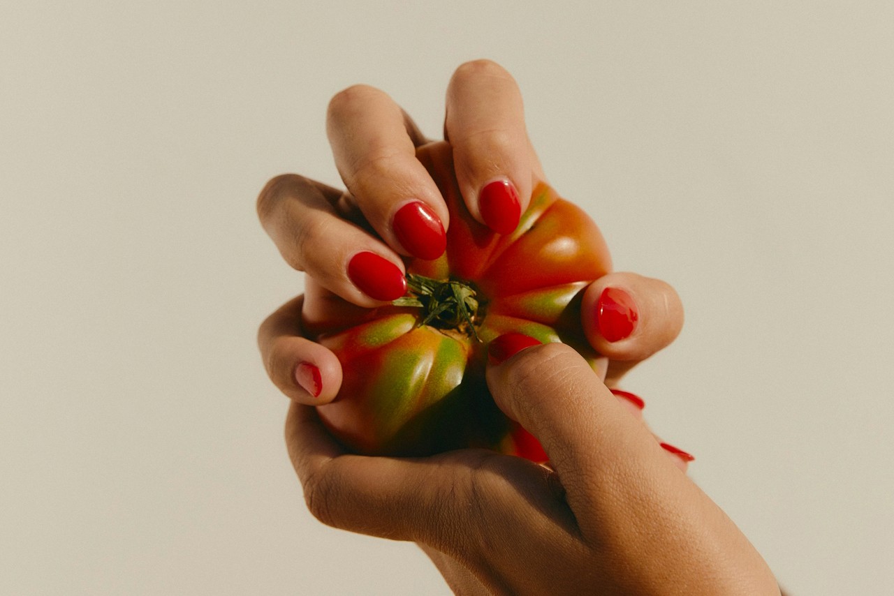 Two hands holding a tomato mood for partner Central market