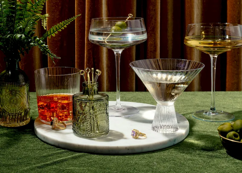 Cocktails sitting on a marble platter on a green table