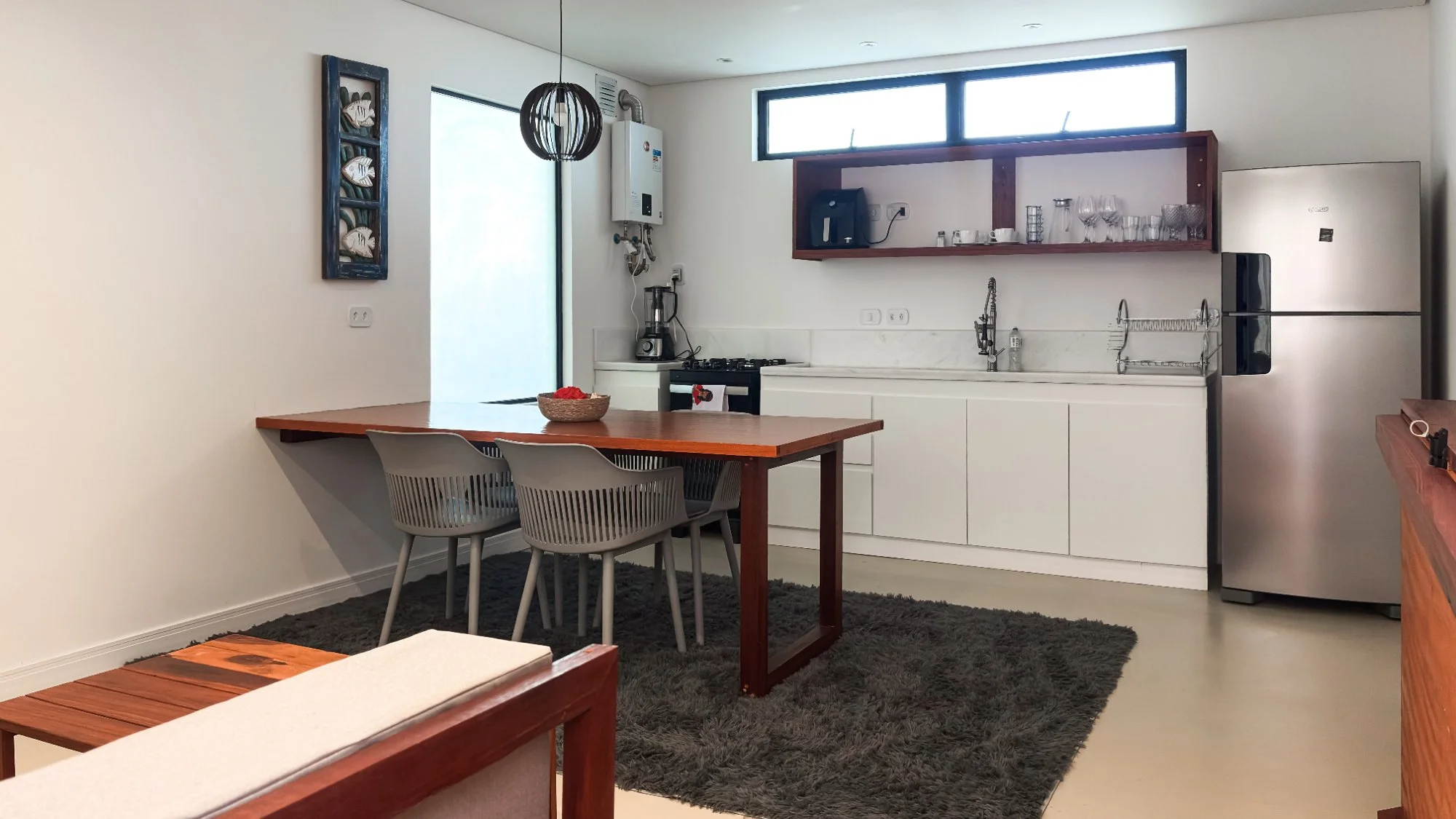 Kitchen and dining area with wooden table, modern chairs, full appliances, and natural light