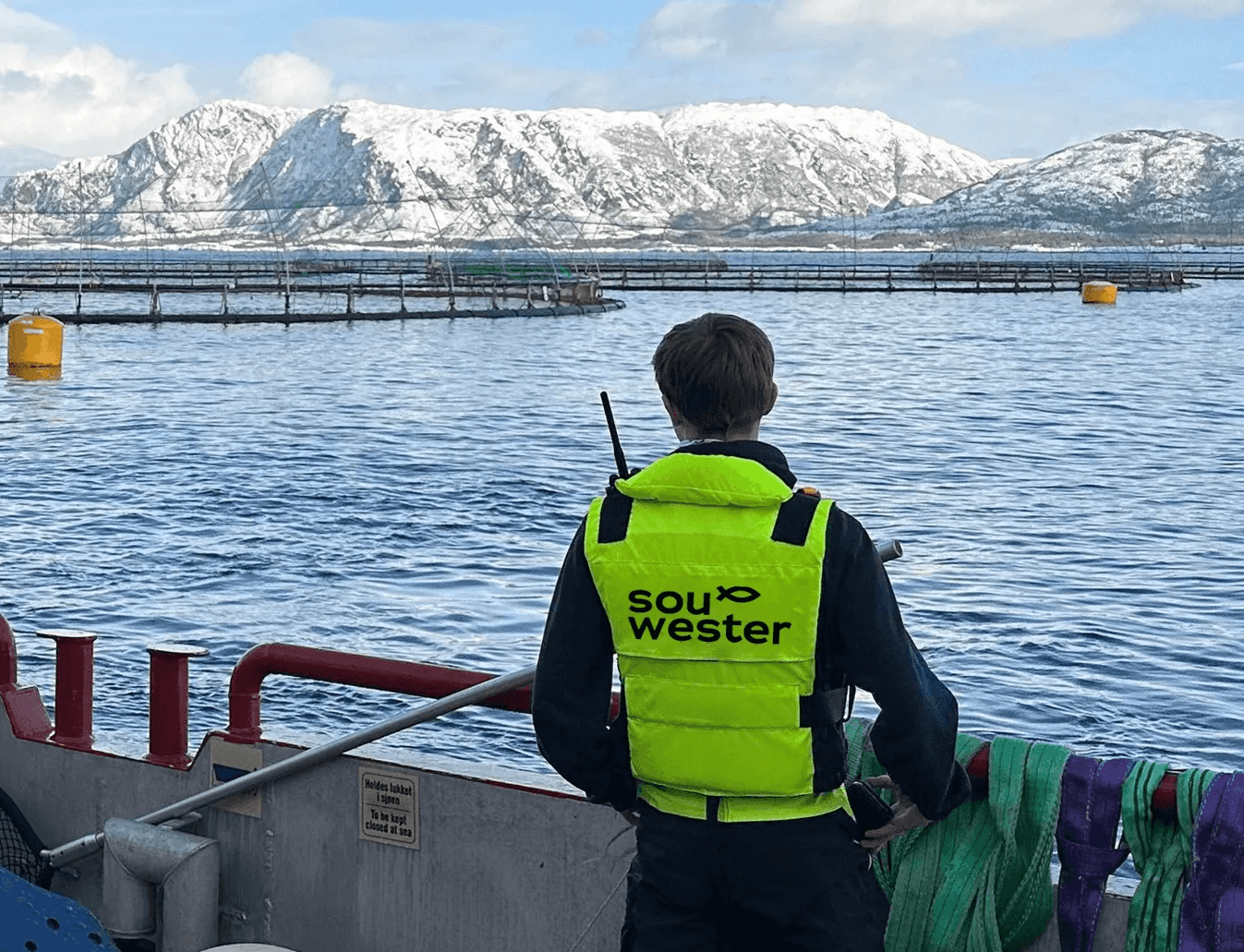souwester ansatt med redningsvest på, hen ser utover anlegget på havet fra arbeidsbåt