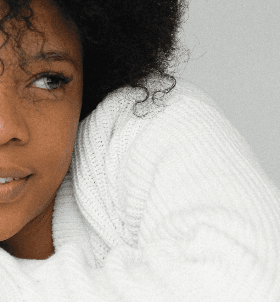 Close up shot on a young woman with dark skin, curly black hair and beautiful lips smiling