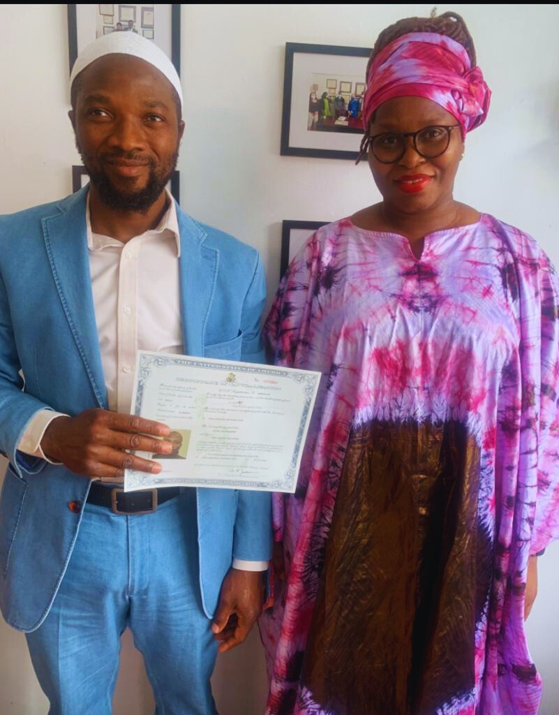 Joyful client holding a green card, assisted by Fibi Law Firm