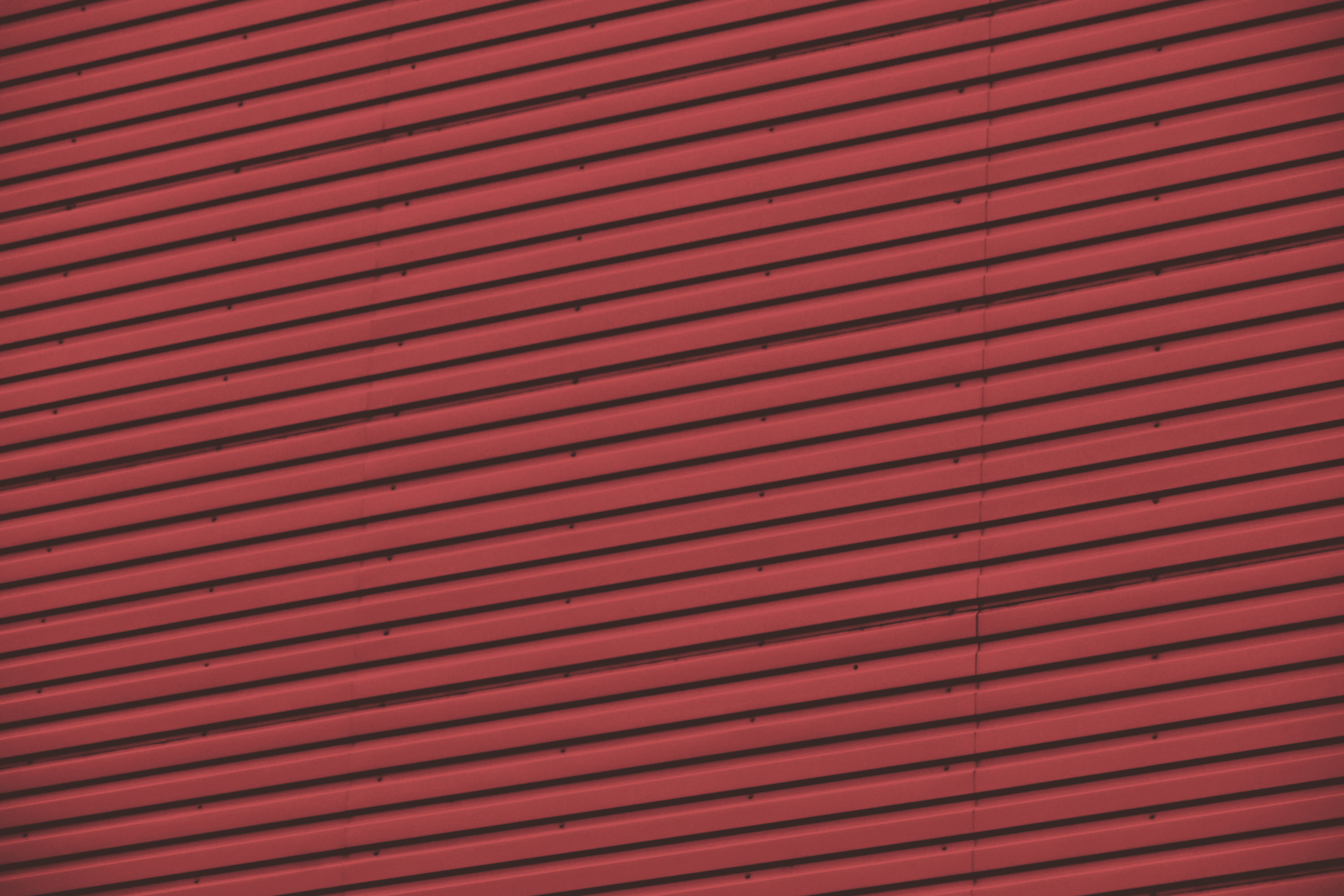 Hands typing on a laptop keyboard on a wooden desk, wearing a brown ribbed sweater