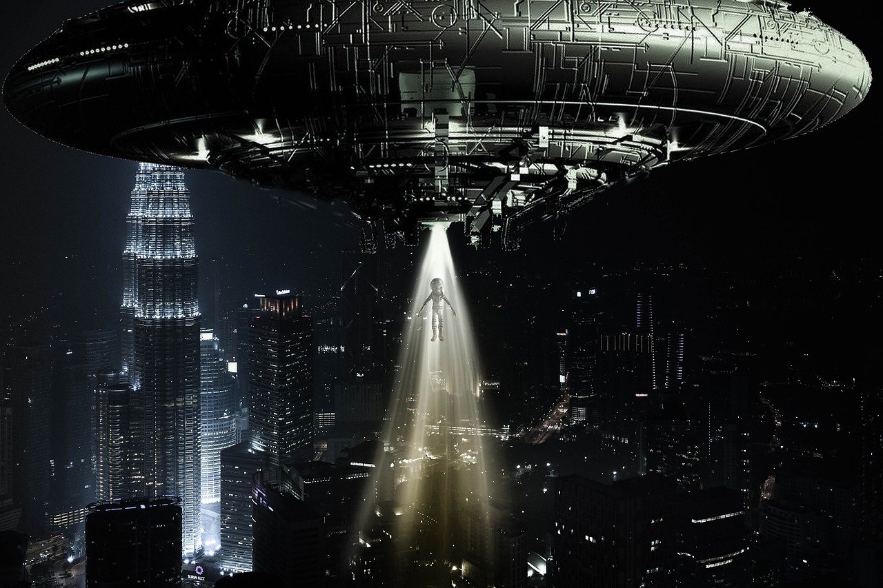 a round alien spacecraft hovering over a city at night while beaming an alien up 