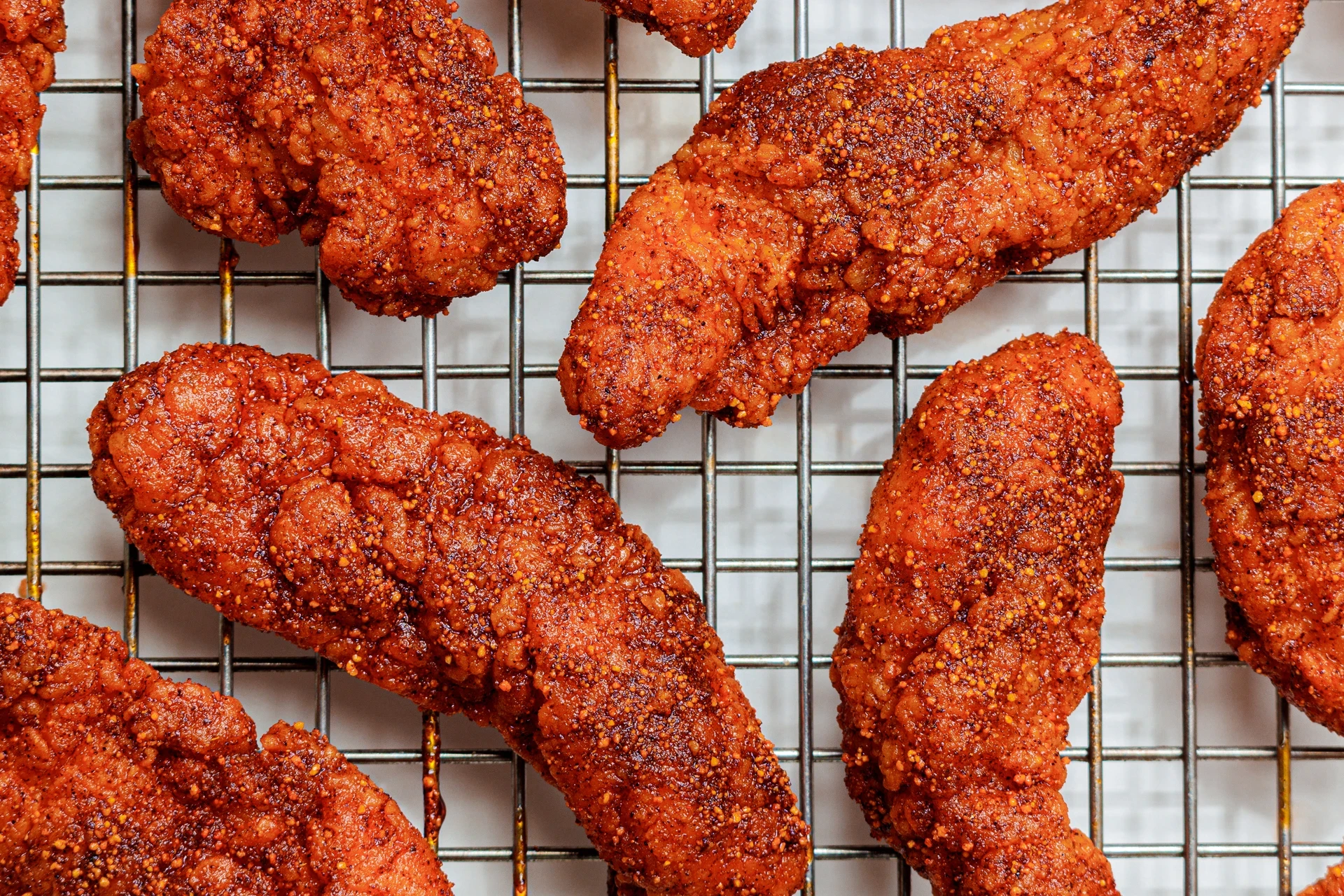 Close up view of spicy chicken wings on a grill.