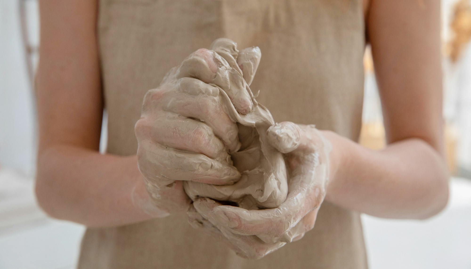 Cours céramique Guérande : mains pétrissant l'argile avant modelage, initiation poterie adulte fait main