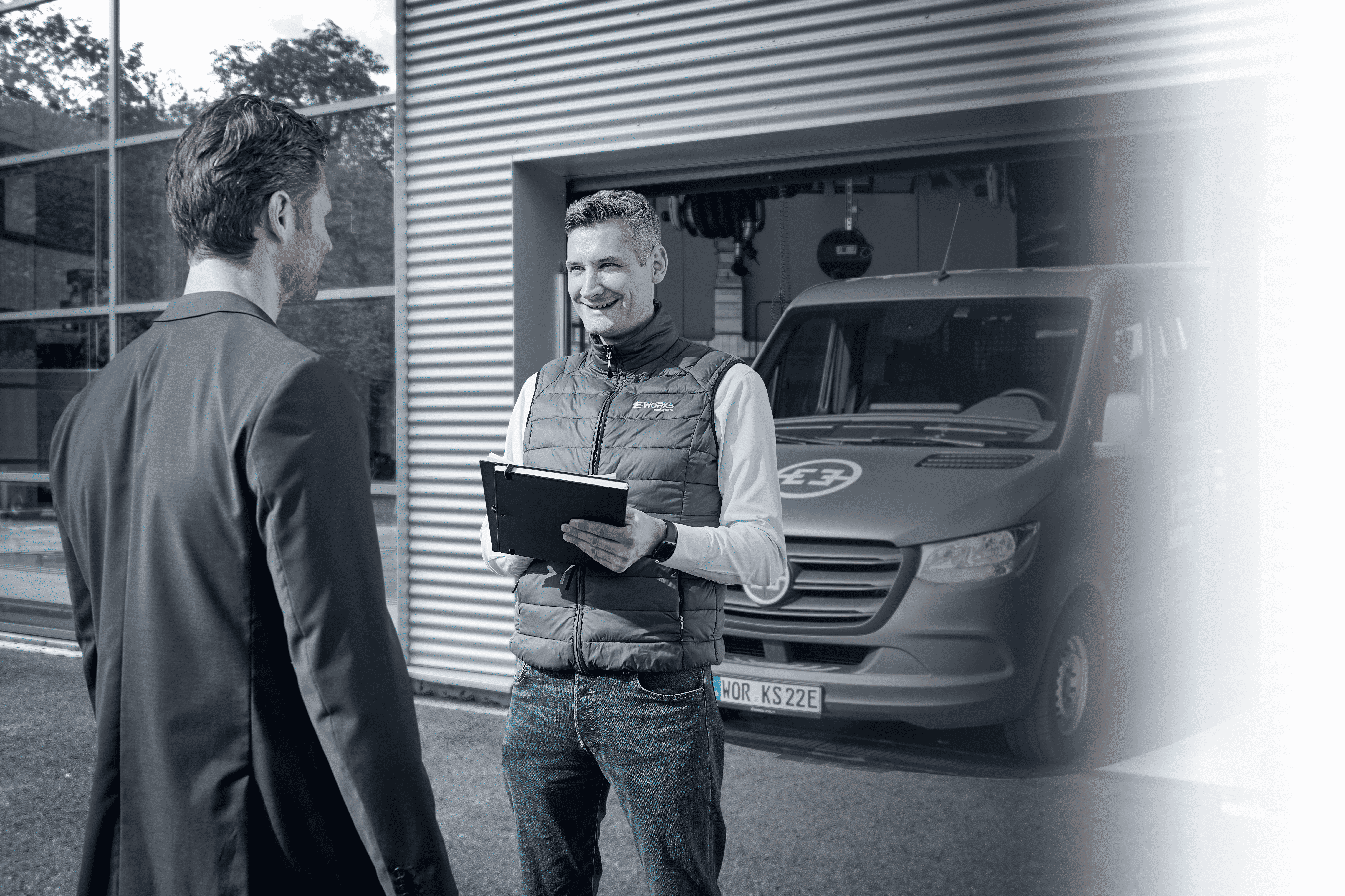 man standing in front of people sitting beside table with laptop computers