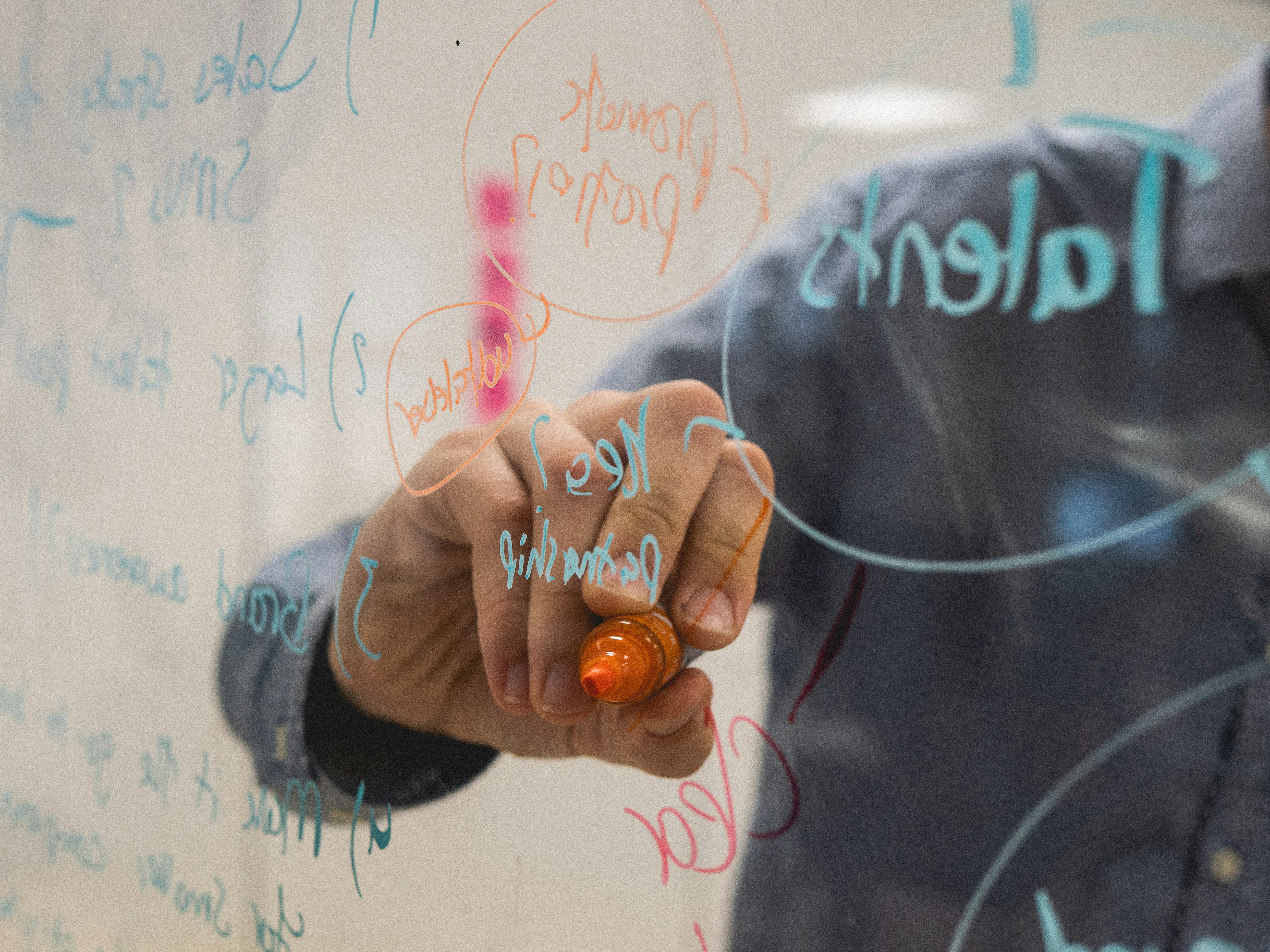 Person Writing on Transparent Board - Heptabase vs Scrintal