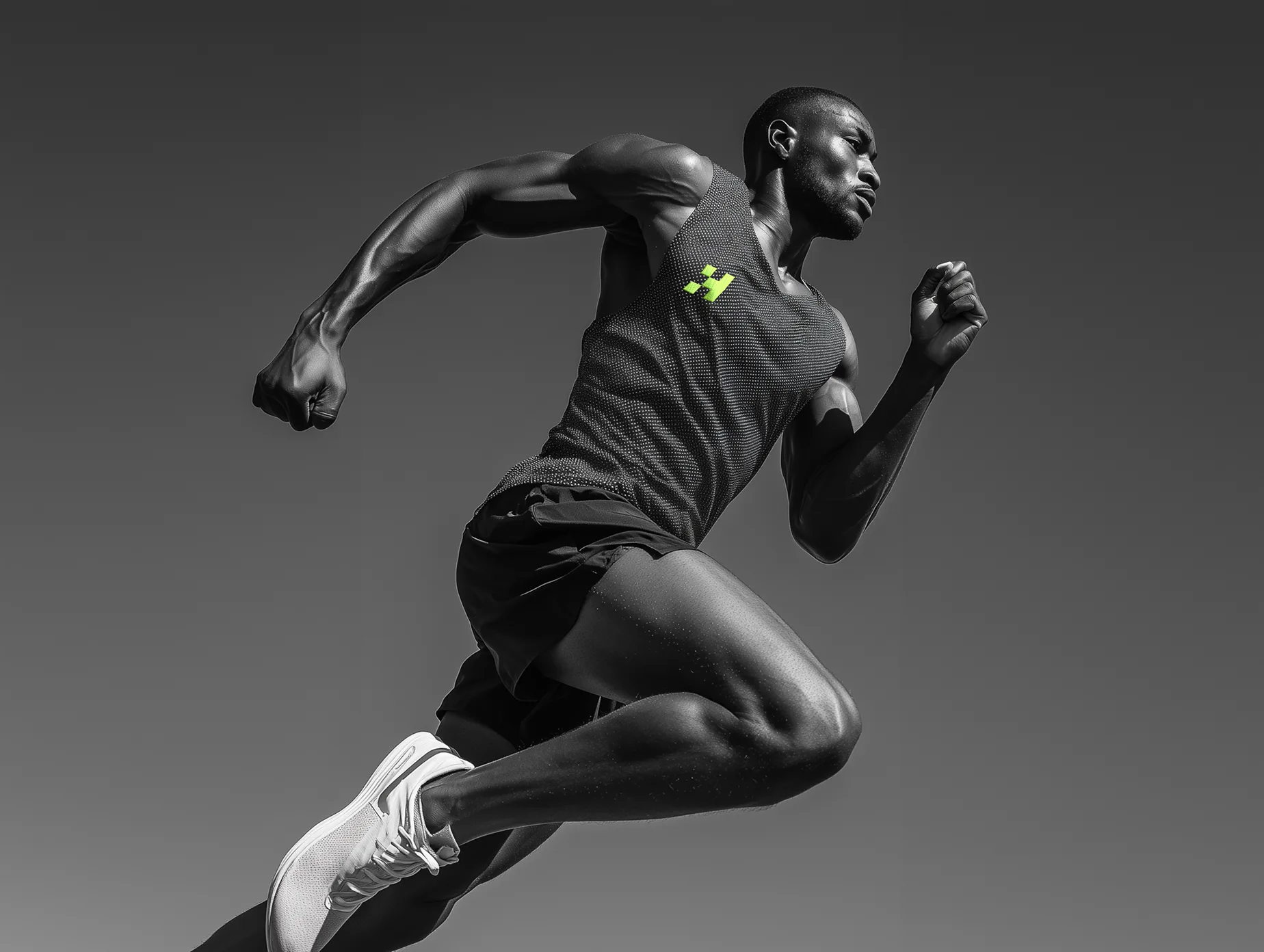 Black and white action photo of an athlete running at speed wearing Hyperdrive athletic wear.