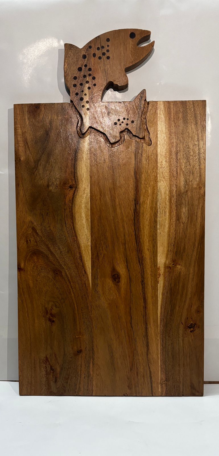 Handcrafted wooden serving board with carved fish handle