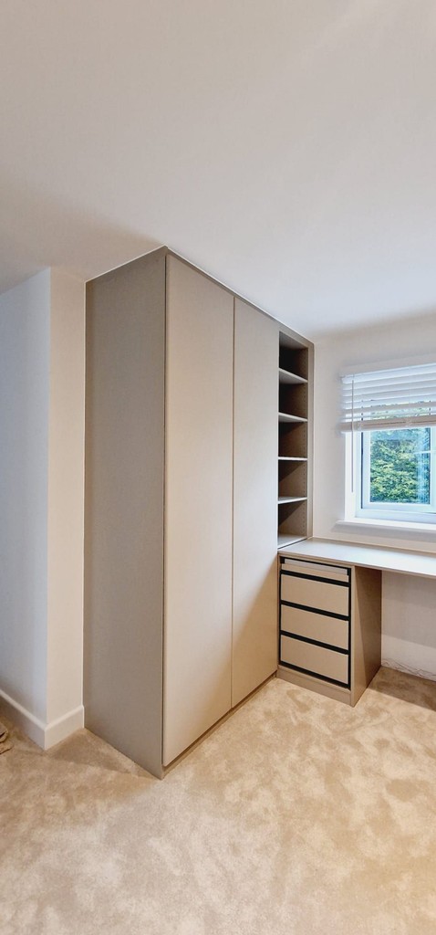 wardrobe and a desk under a window
