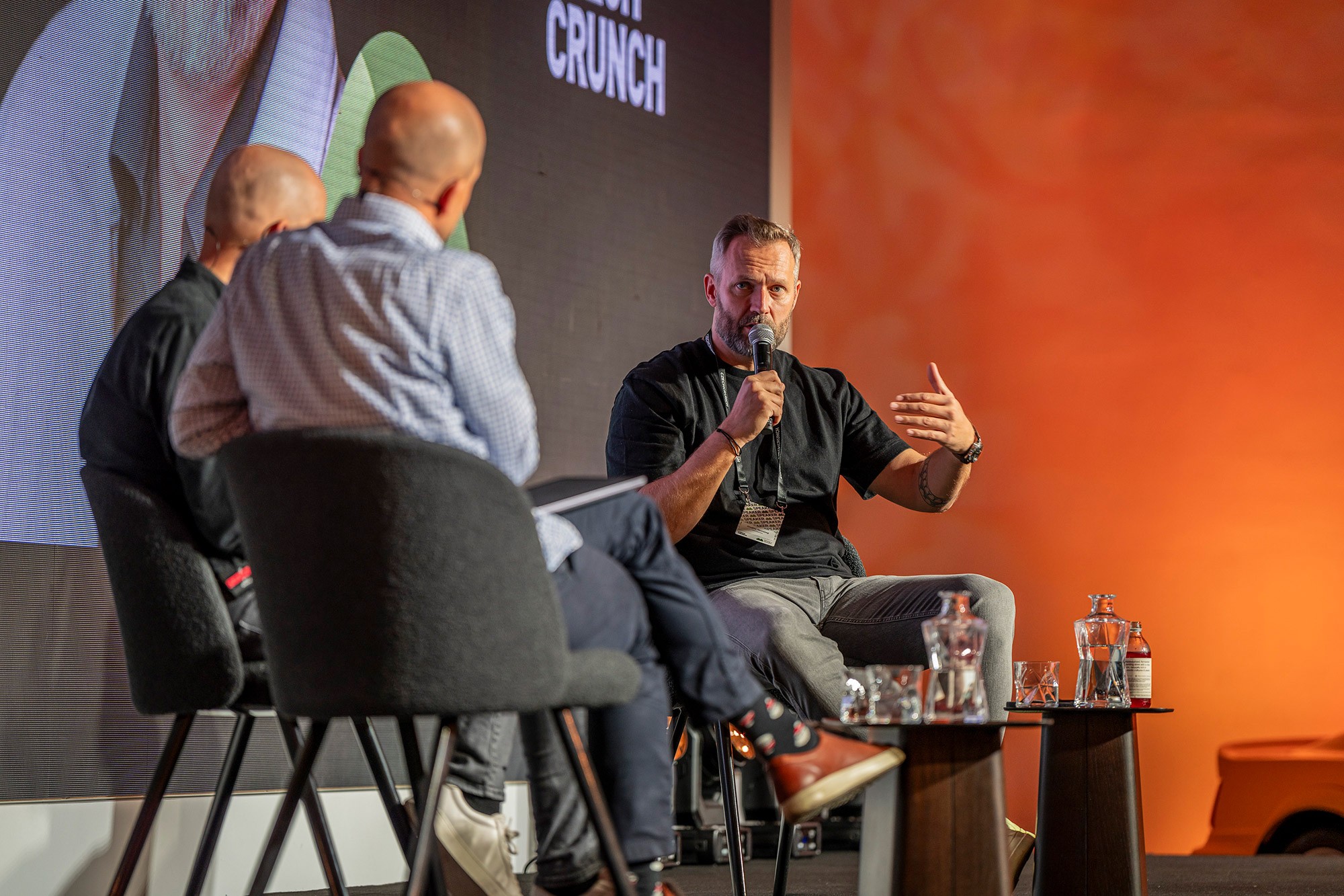 Ondřej Novotný speaking on stage during a panel discussion at the Money Maker business conference in Prague.