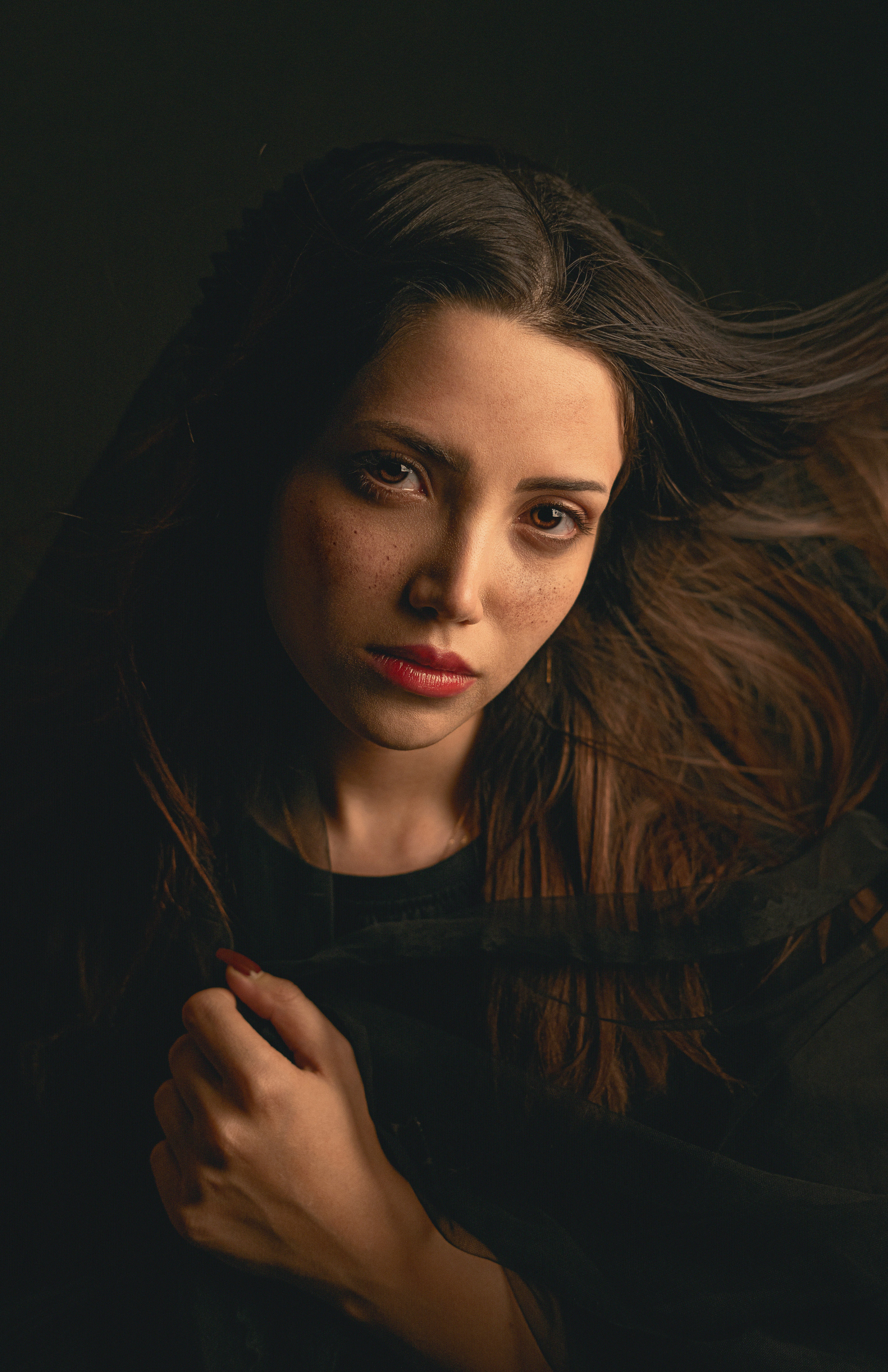Young woman with long brown hair and freckles.