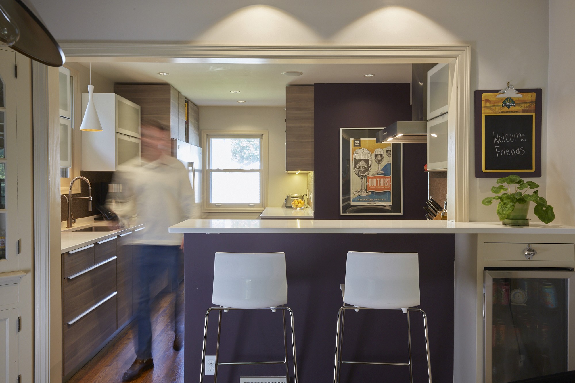 Open kitchen breakfast bar with purple accent wall in the Diamond Lake renovation, Minneapolis