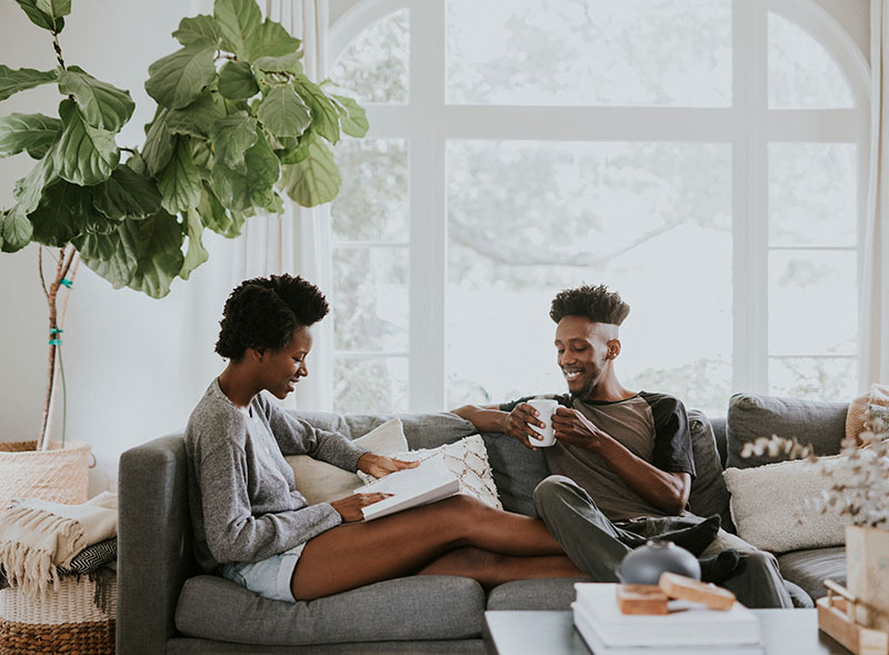 man and woman hanging out on couch