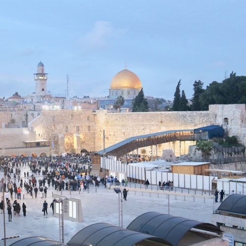 Crowds gathered near the Western Wall, with the golden Dome of the Rock and other historic buildings in the background.