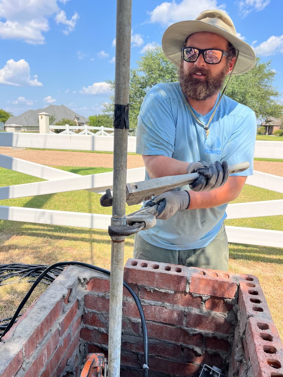 Submersible pump being pulled during well repair in Dallas.