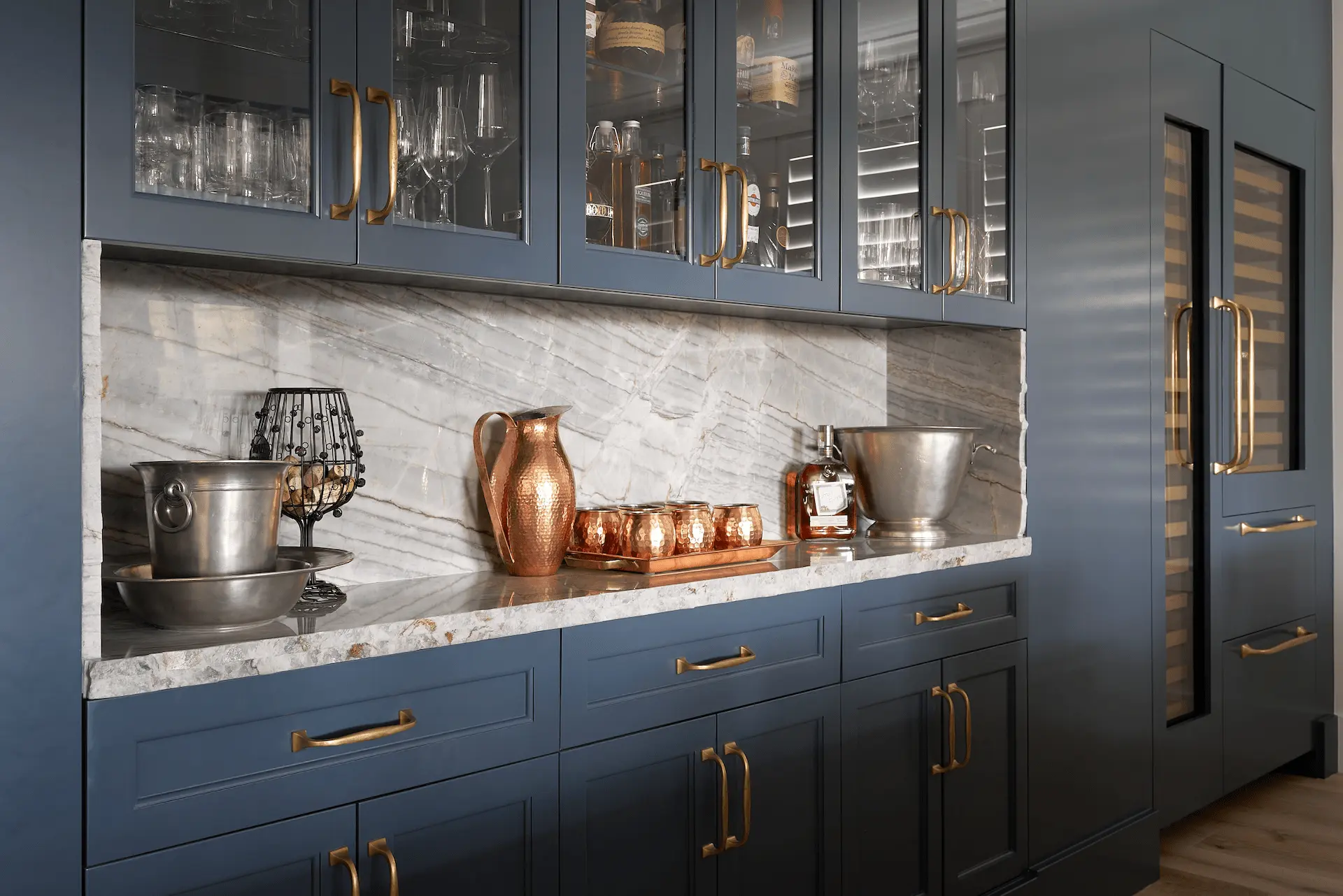 Wide view of the bar cabinetry and wine fridge, illustrating the seamless integration of storage and luxury amenities in the Ladera Ranch Remodel's contemporary coastal design. Photo by Todd Huge.