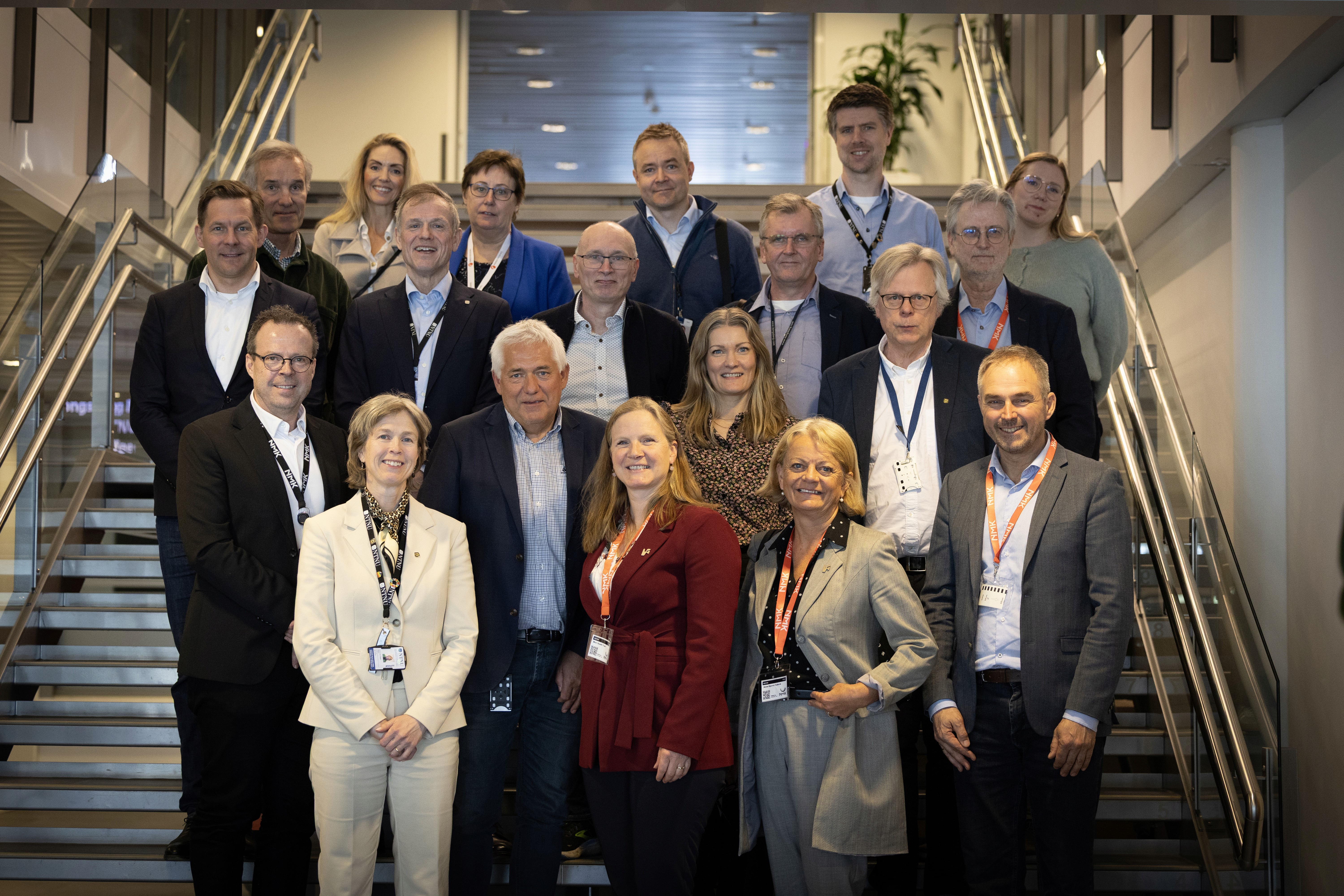 A person wearing a virtual reality headset stands in front of multiple screens, engaged in a digital experience.