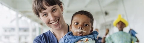 Volunteer holding a baby