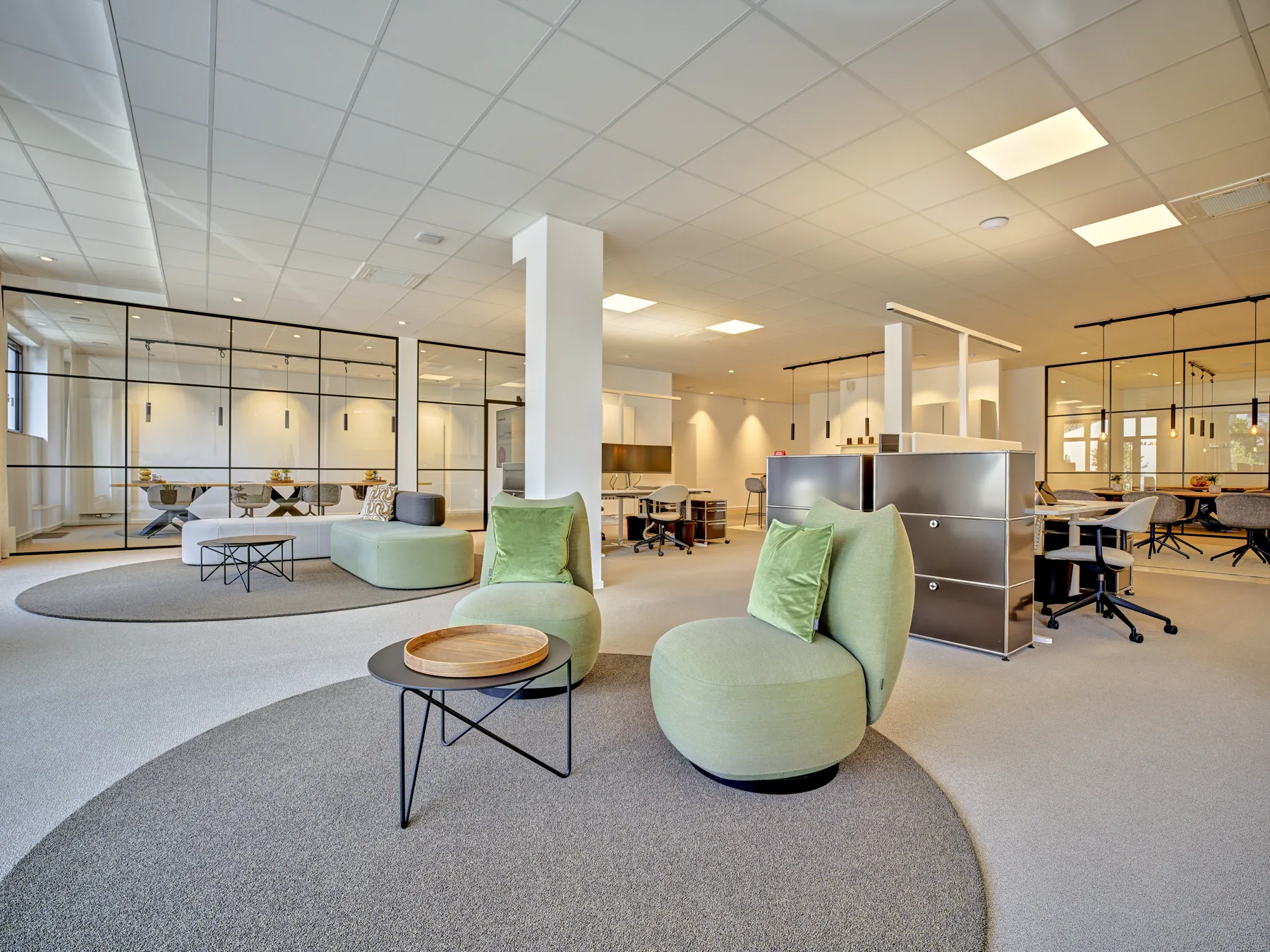 Open Space mit runder Sitzinsel und grünen Sesseln