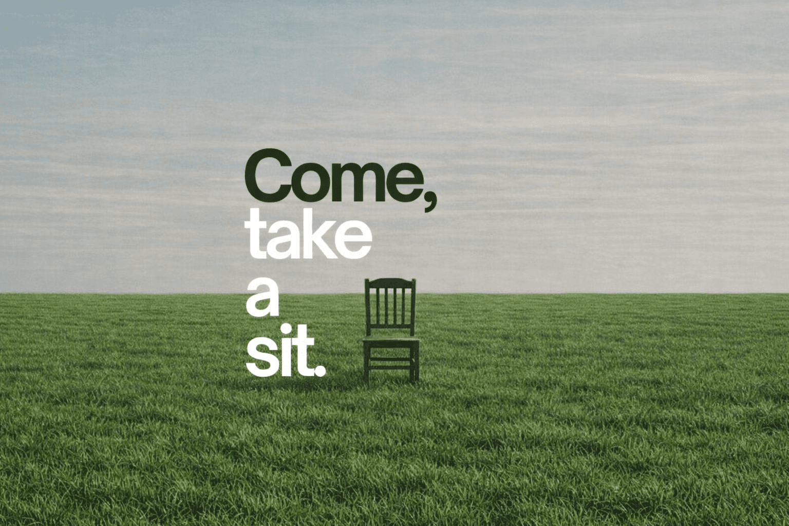 A cozy seating area with a sign encouraging visitors to take a seat.