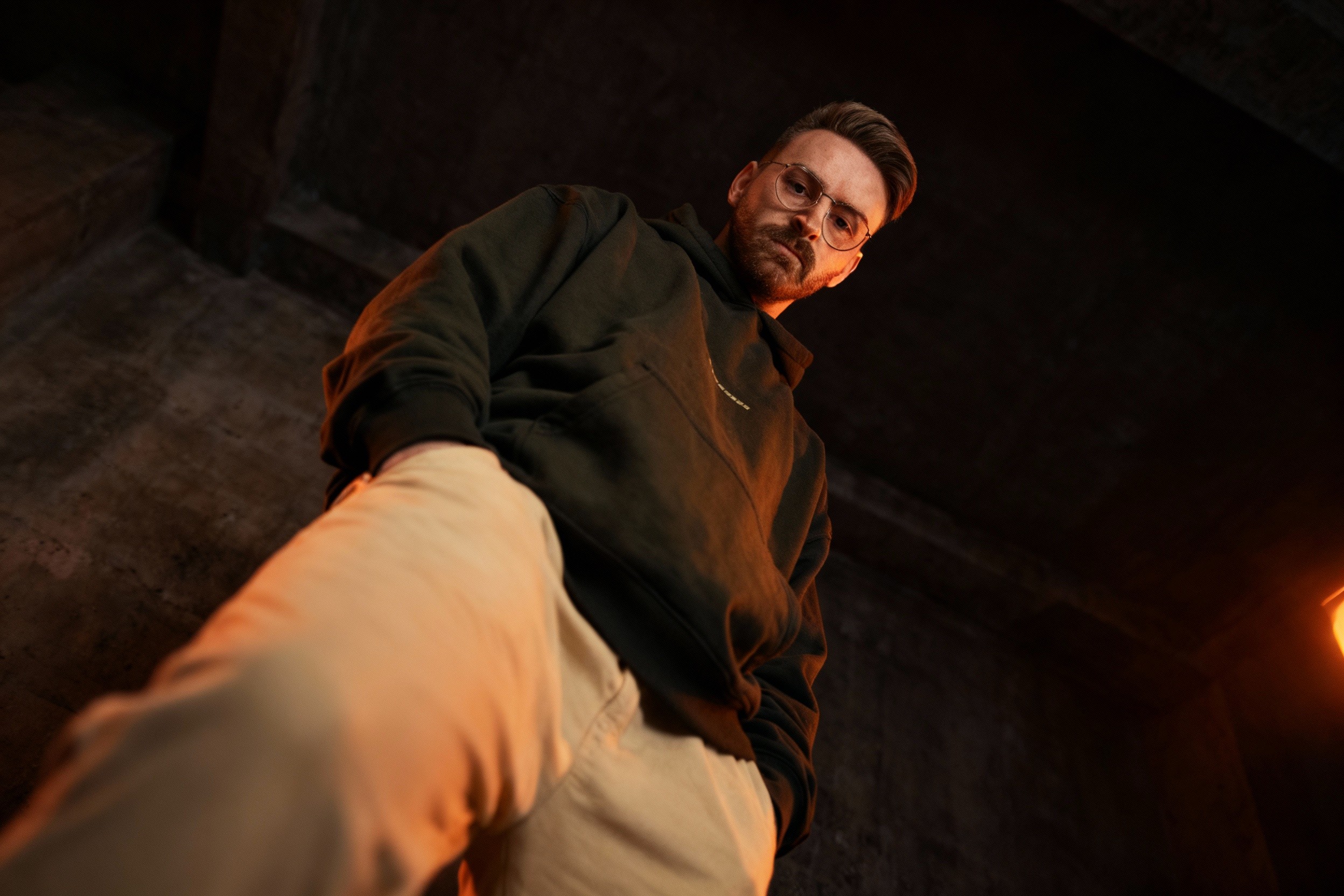 man looking down to thebground into the camera