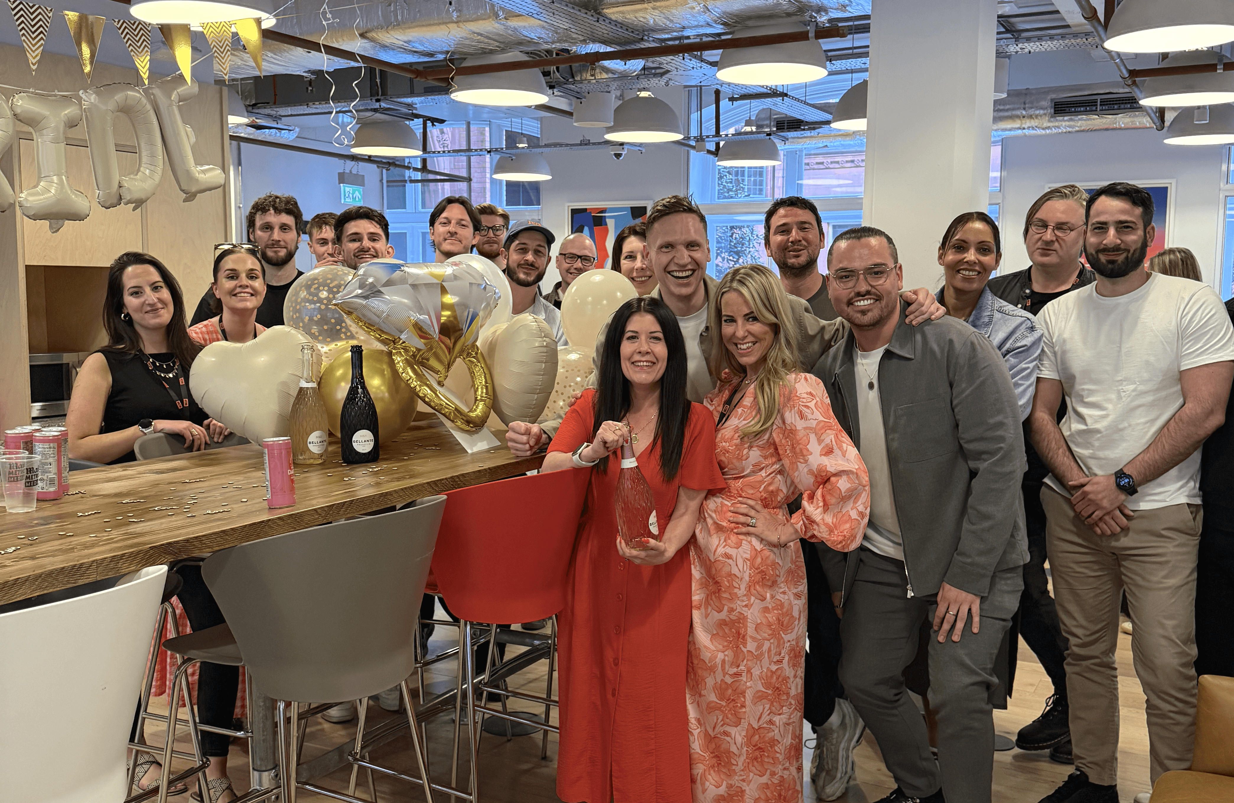 Large group of people gathered indoors celebrating wedding.