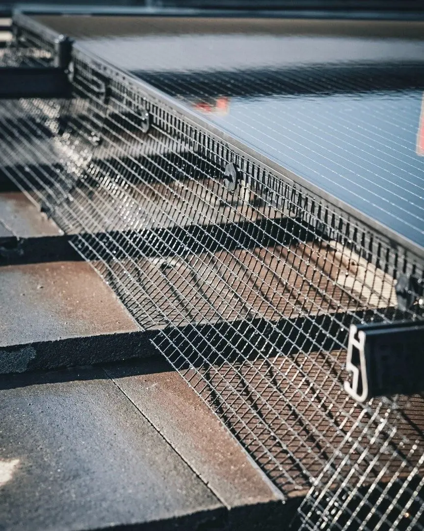 Bird-proofing mesh installed under a solar array on a tile roof | Premier Solar Service, serving Central Valley, CA
