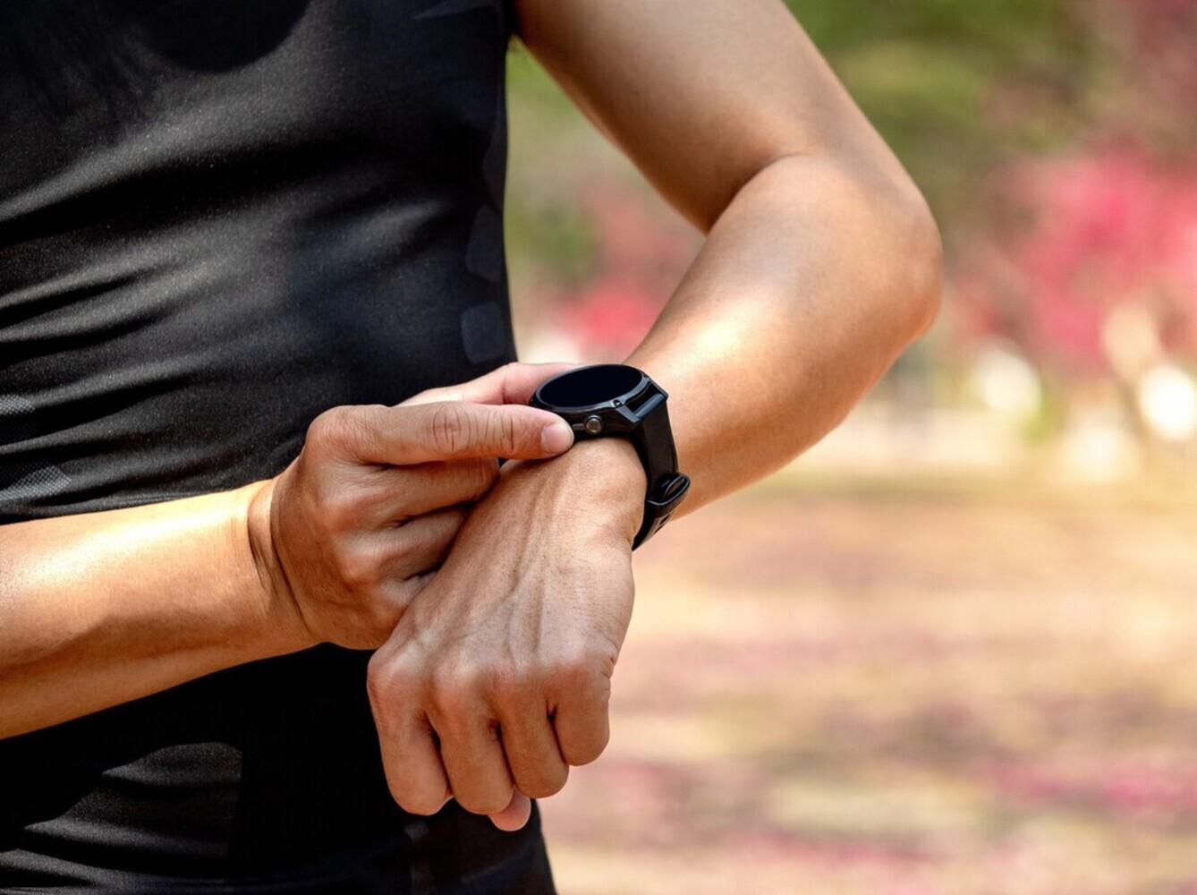 man checking his fitness tracker to see how well he’s doing for how to walk for weight loss in terms of distance