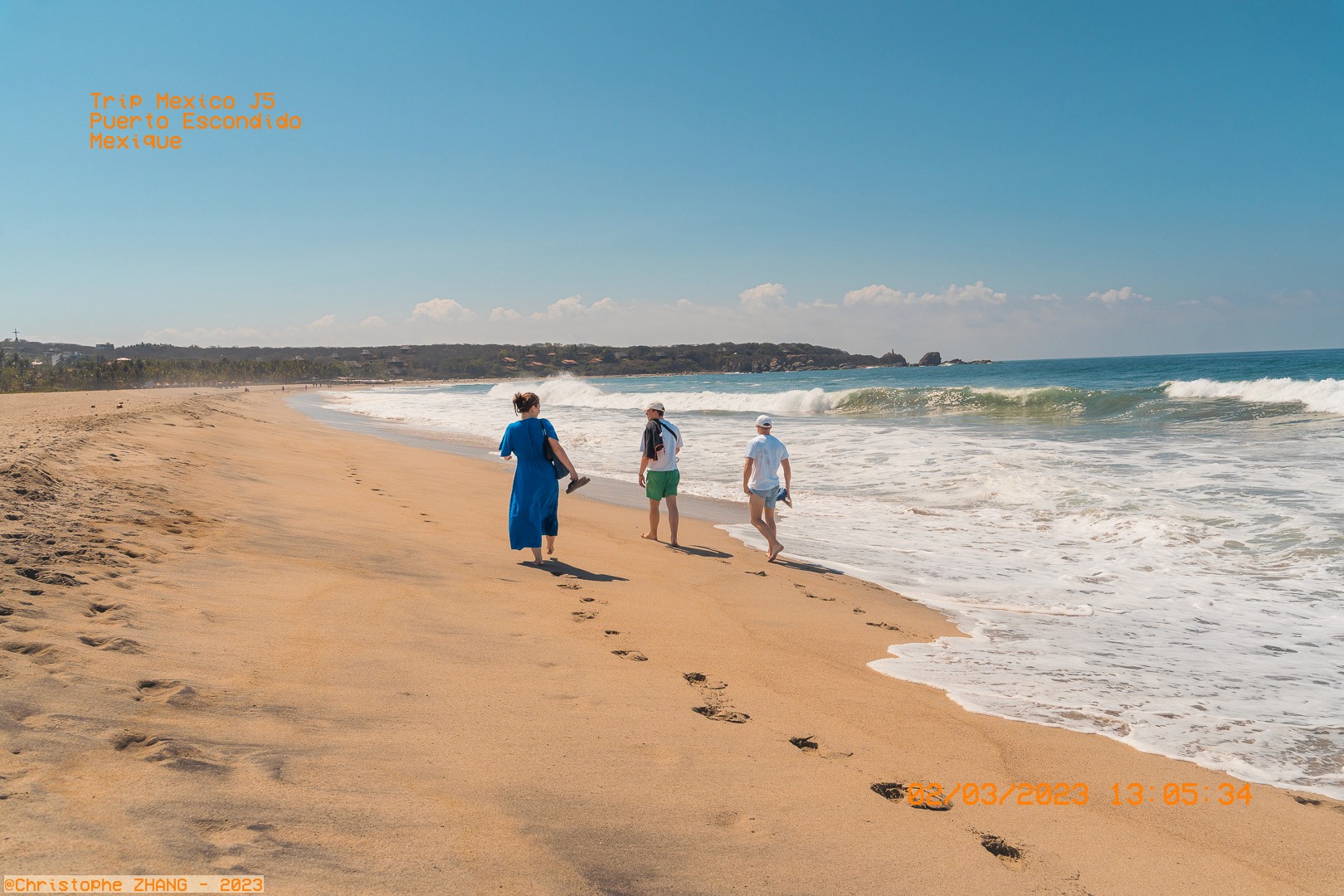 Promenade sur le sable au bord de l'océan à Puerto Escondido, par une journée ensoleillée.
